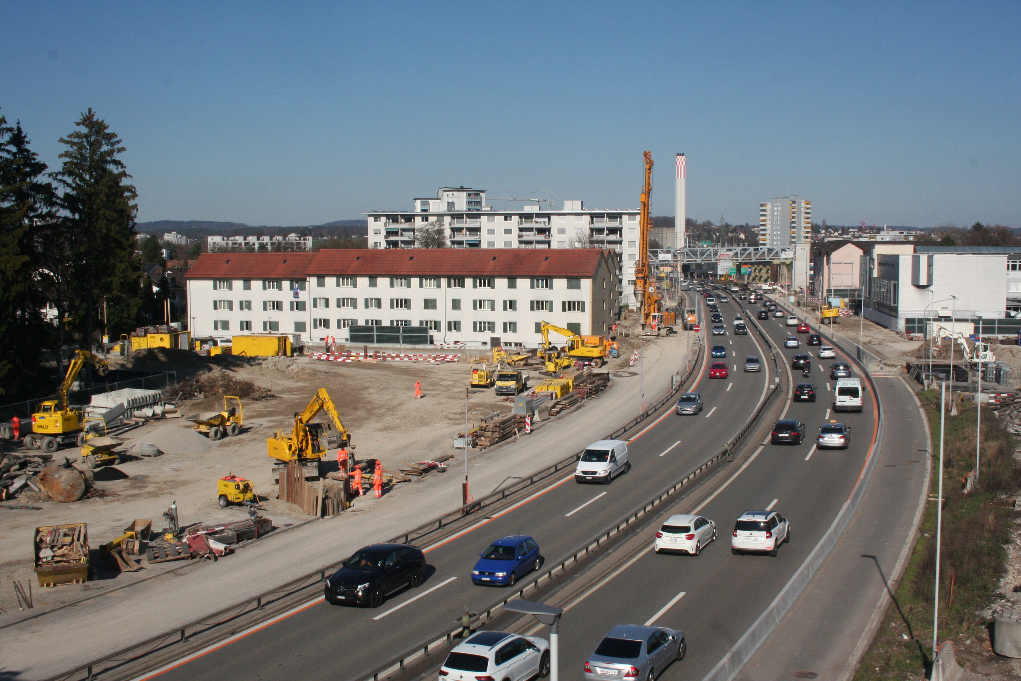 Sicht von der provisorischen Fussgängerbrücke auf die Autobahn, im Hintergrund das Heizkraftwerk. Im sichtbaren Bereich der A1 käme das Portal Aubrugg zu liegen. Im Februar 2016 hat die Plangenehmigungsverfügung (PGV) für das Projekt Einhausung Schwamendingen Rechtskraft erlangt.