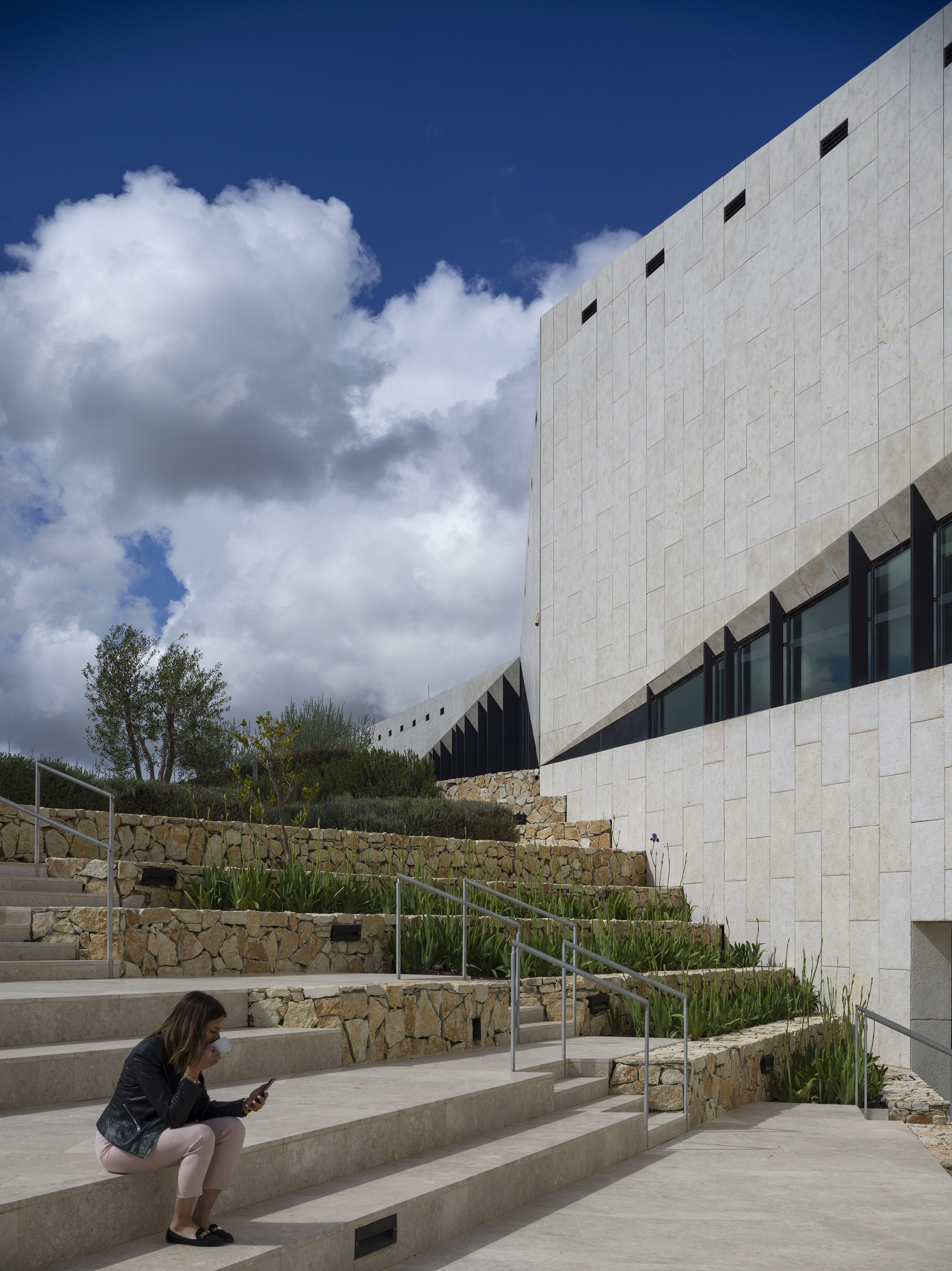 Woman drinking a cup of coffee in the outdoor amphitheatre.