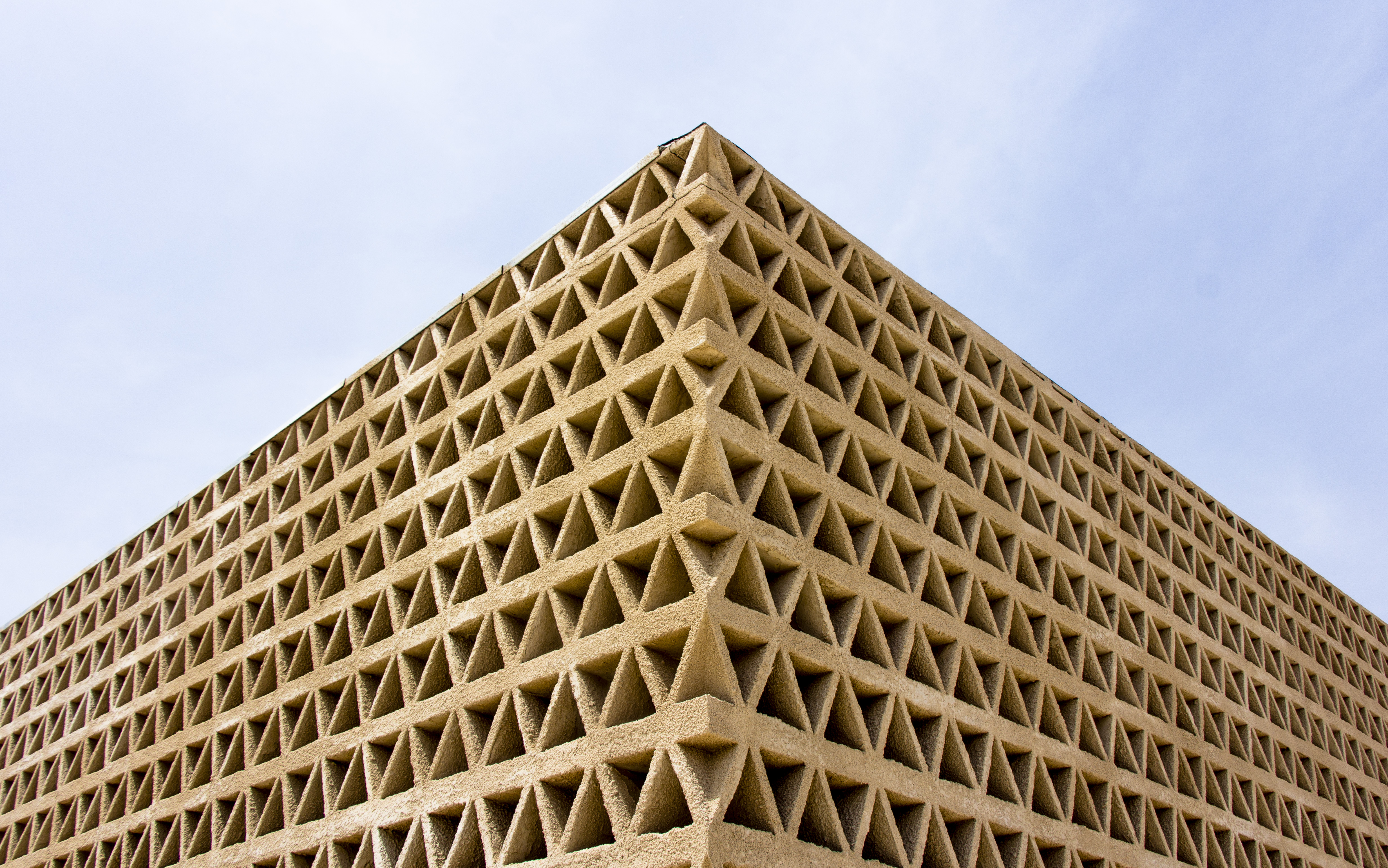 The façade is made of 20,000 blocks with triangular perforations. They were moulded in situ by the local workforce and then air-dried. The construction of the 2,000 m2 south elevation lattice, employed over a hundred workers from Bambey for 6 months.