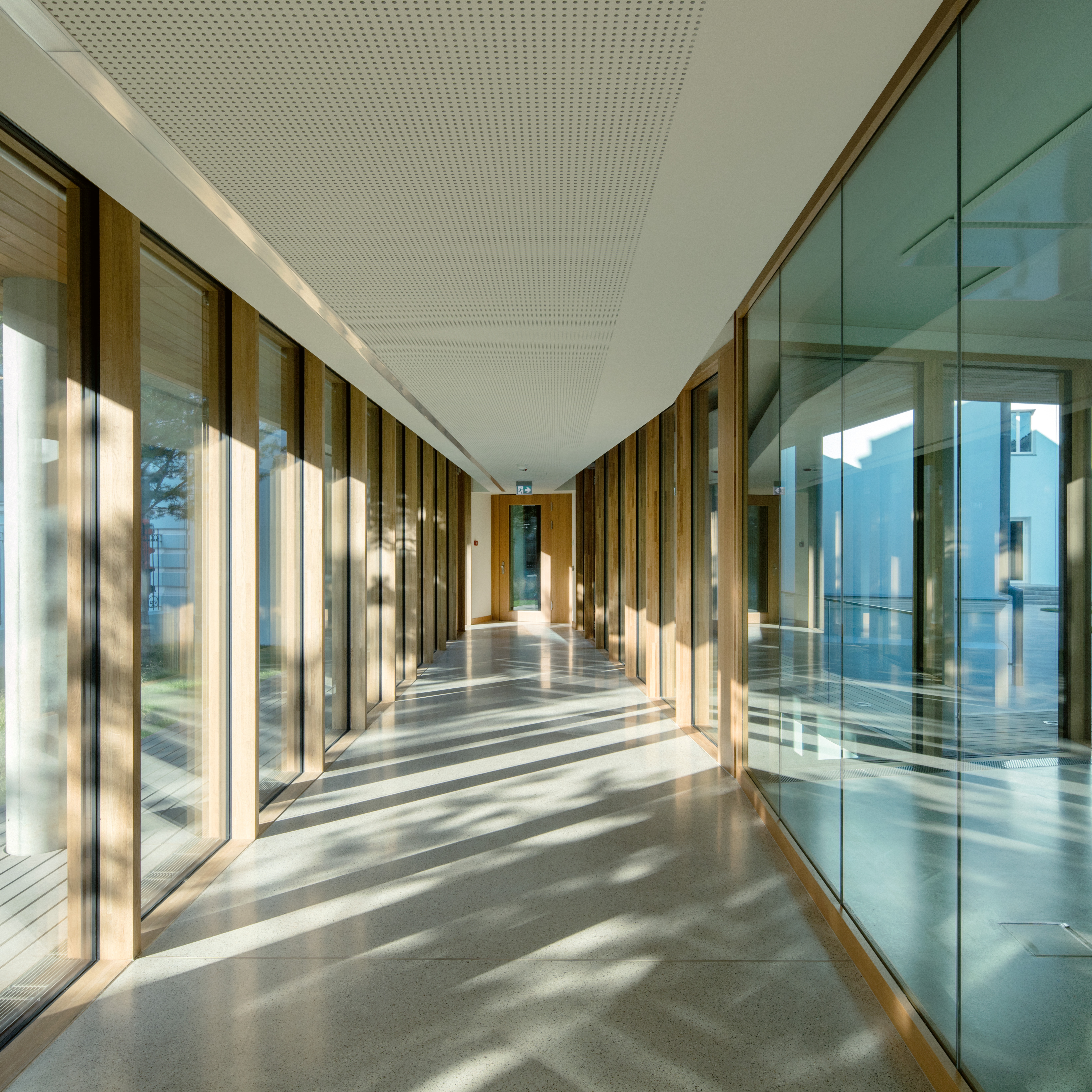 Le patio central unifie les services de l’ensemble diplomatique. Les visiteurs circulent par un couloir entourant ce patio, baignant dans la lumière et ponctué d’espaces de réunion ou de réception en double hauteur.