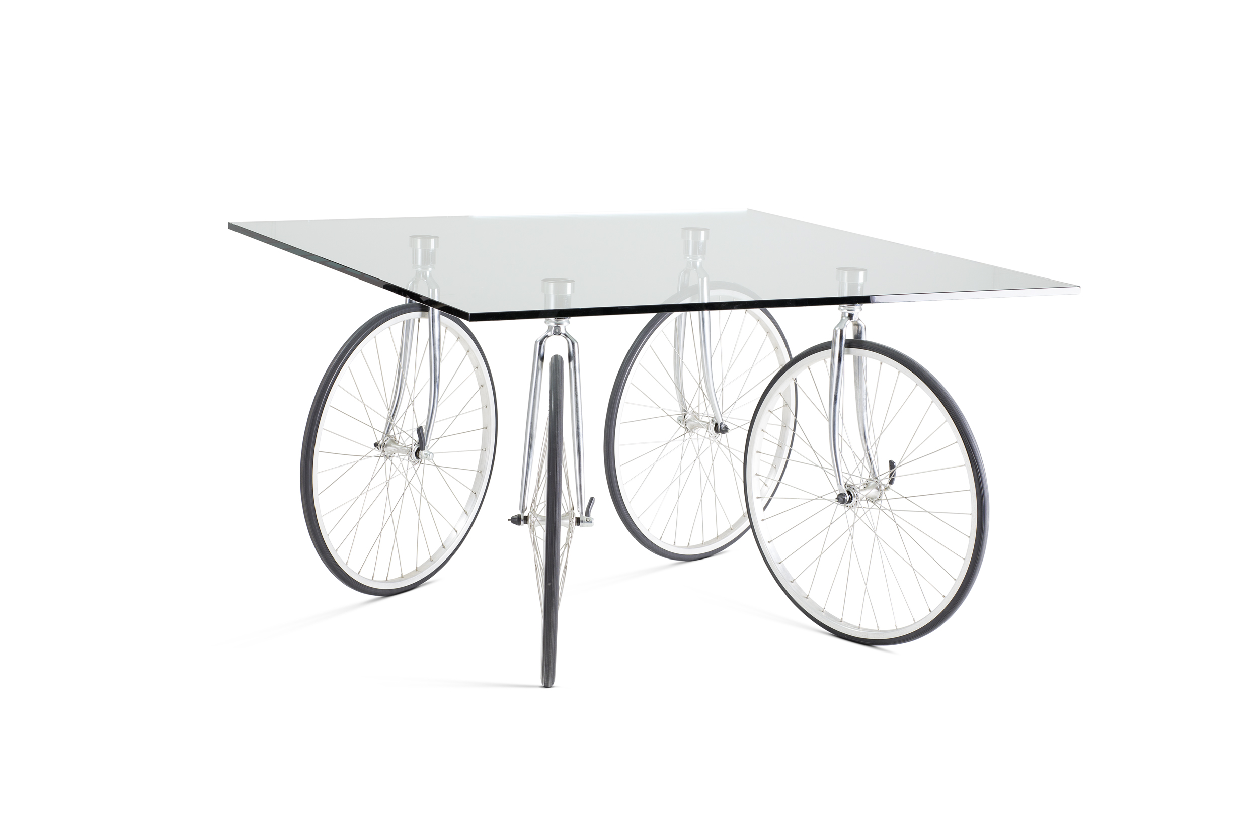 Der Tisch «Tour» von Gae Aulenti (1993) ist eine Ableitung vom kleineren «Tavolo con Ruote». In Anlehnung an «Le Tour de France» dienen Veloräder als Tischbeine. Tischplatte aus 15 mm starkem, geschliffenem Floatglas. Hersteller: FontanaArte, Corsico/Milano I.