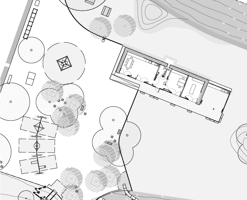 Der Holzbau liegt am Rand des Parks und ist über einen seitlichen Eingang erschlossen.