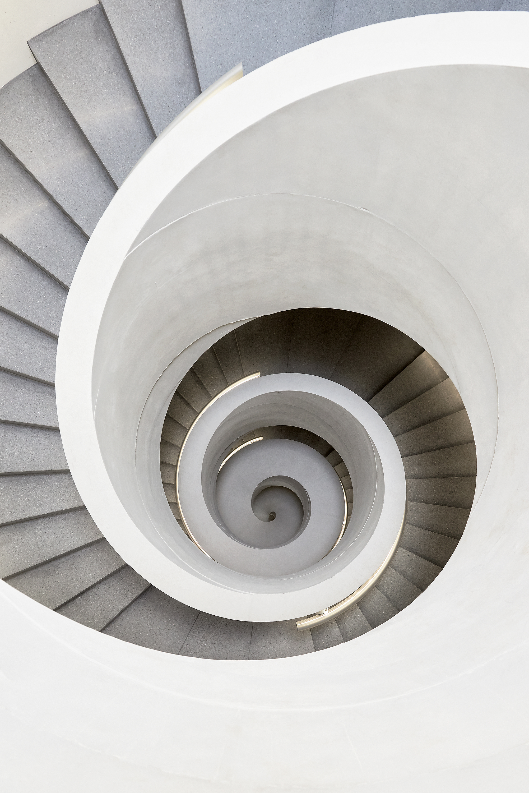Die Spindel­treppe mit ihrem  zunehmenden Kerndurchmesser der Brüstung bringt die Lasten punktgenau in die Untergeschosse.