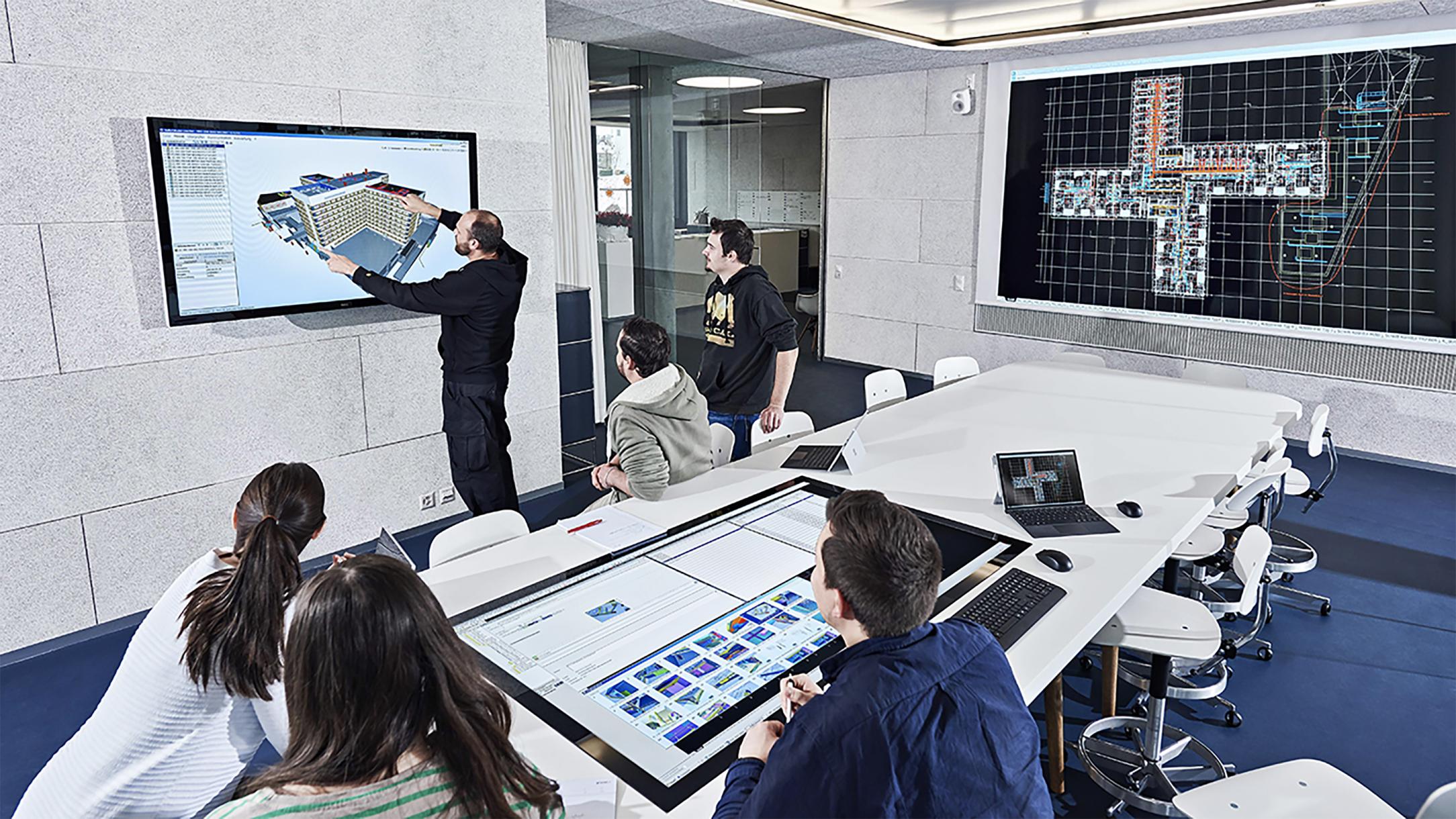 Gli esperti lavorano insieme sul gemello digitale di un edificio. La progettazione tramite BIM (Building Information Modeling) permette di dare una rappresentazione virtuale di tutte le informazioni relative all'edificio e di lavorare in contemporanea sul modello.