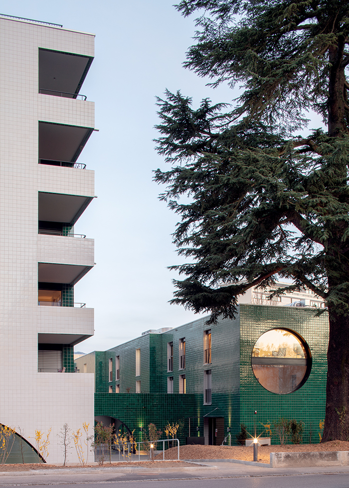 Vue des deux volumes depuis le chemin des Pâquerettes, à Lancy. Le plus haut des deux abrite des logements sociaux, alors que celui couleur jade accueille des logements étudiants ainsi que des habitations de la fondation Sgipa pour personnes présentant une forme de déficience intellectuelle.
