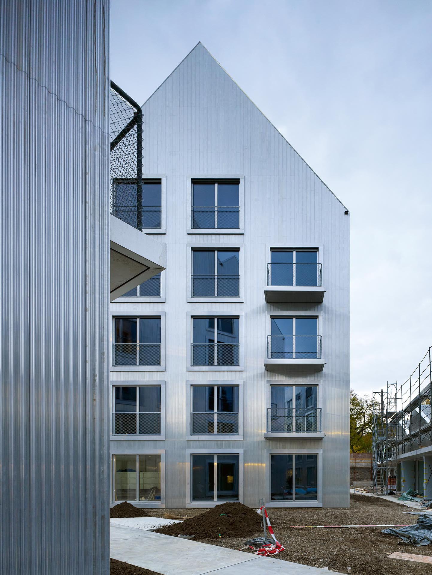 Wohnhäuser an der Hardstrasse 43 in Basel, Architektur Müller &amp; Maranta: Die Fassade und die Dacheindeckung der drei Neubauten bestehen aus demselben und objektspezifisch entwickelten Aluminium-Profilsystem.