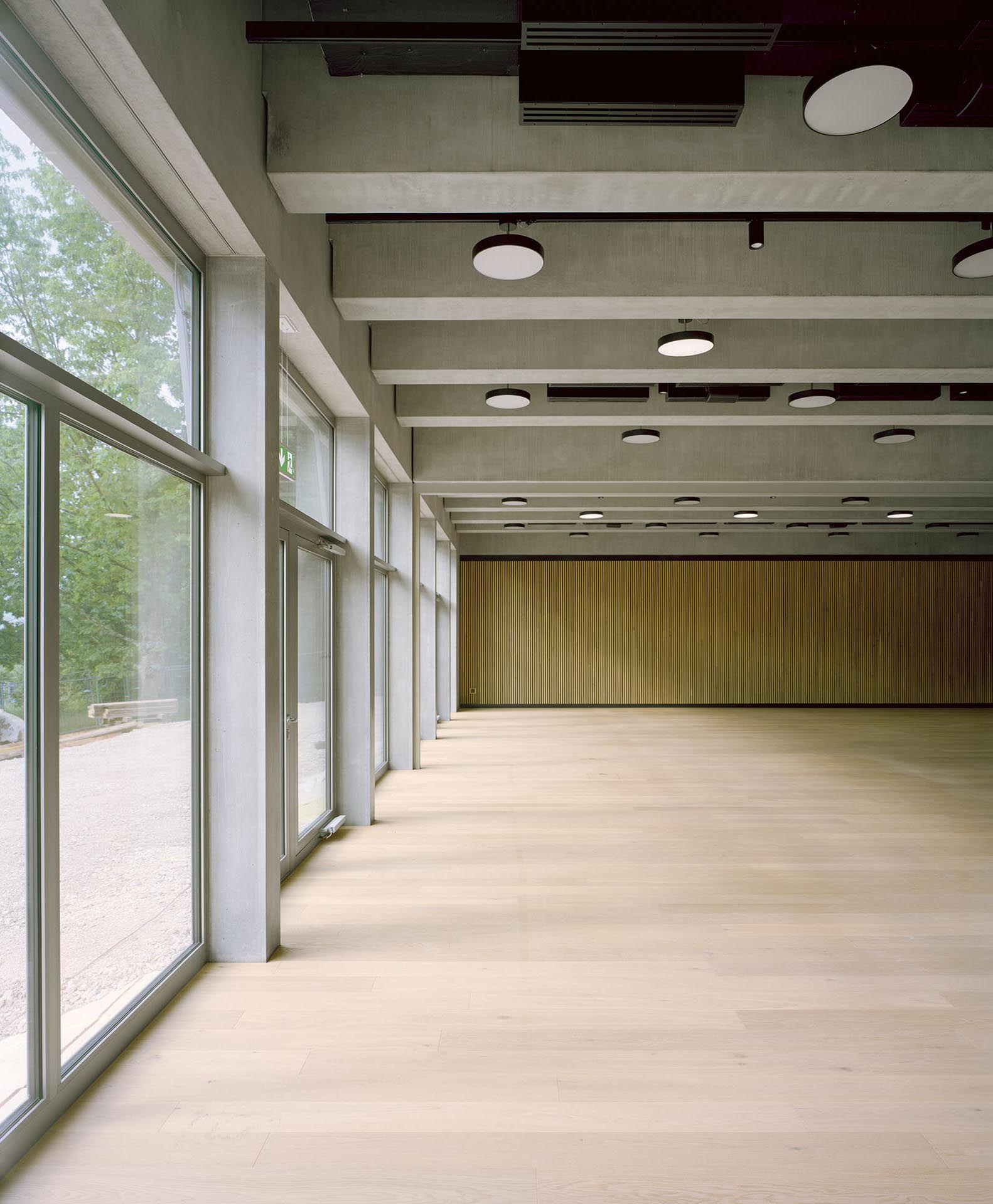 Vue de la grande salle, au rez-de-chaussée, avec ses poutres préfabriquées en béton.