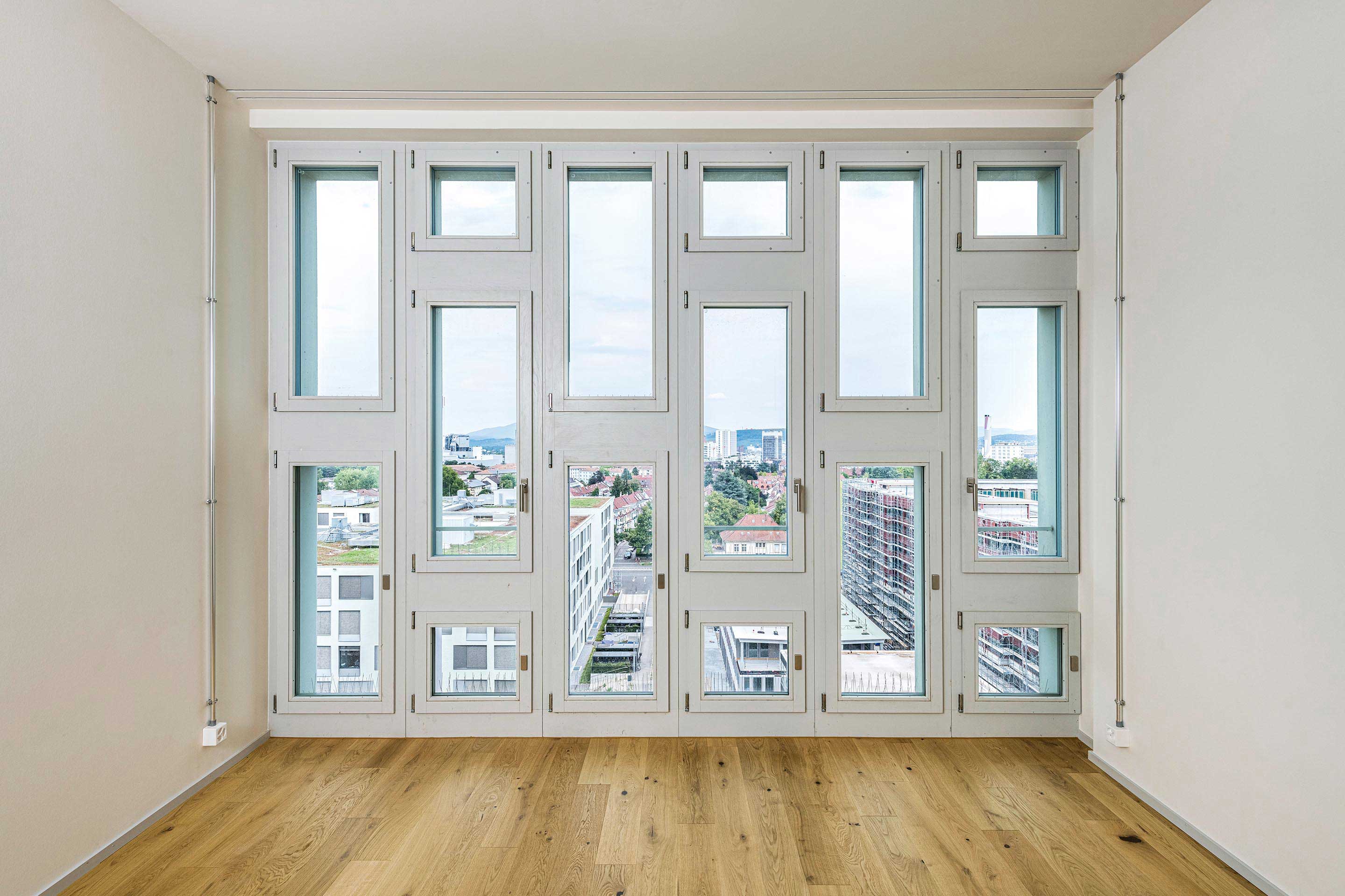 Die innere Betonfertigteilfassade hat neue Fenster erhalten, die die Planenden in der Ansichtsbreite und der Farbe möglichst gleich wählten wie die ersetzten Fenster. Aus den dahinterliegenden Zimmern hat man einen wunderbaren Blick auf die Stadt.