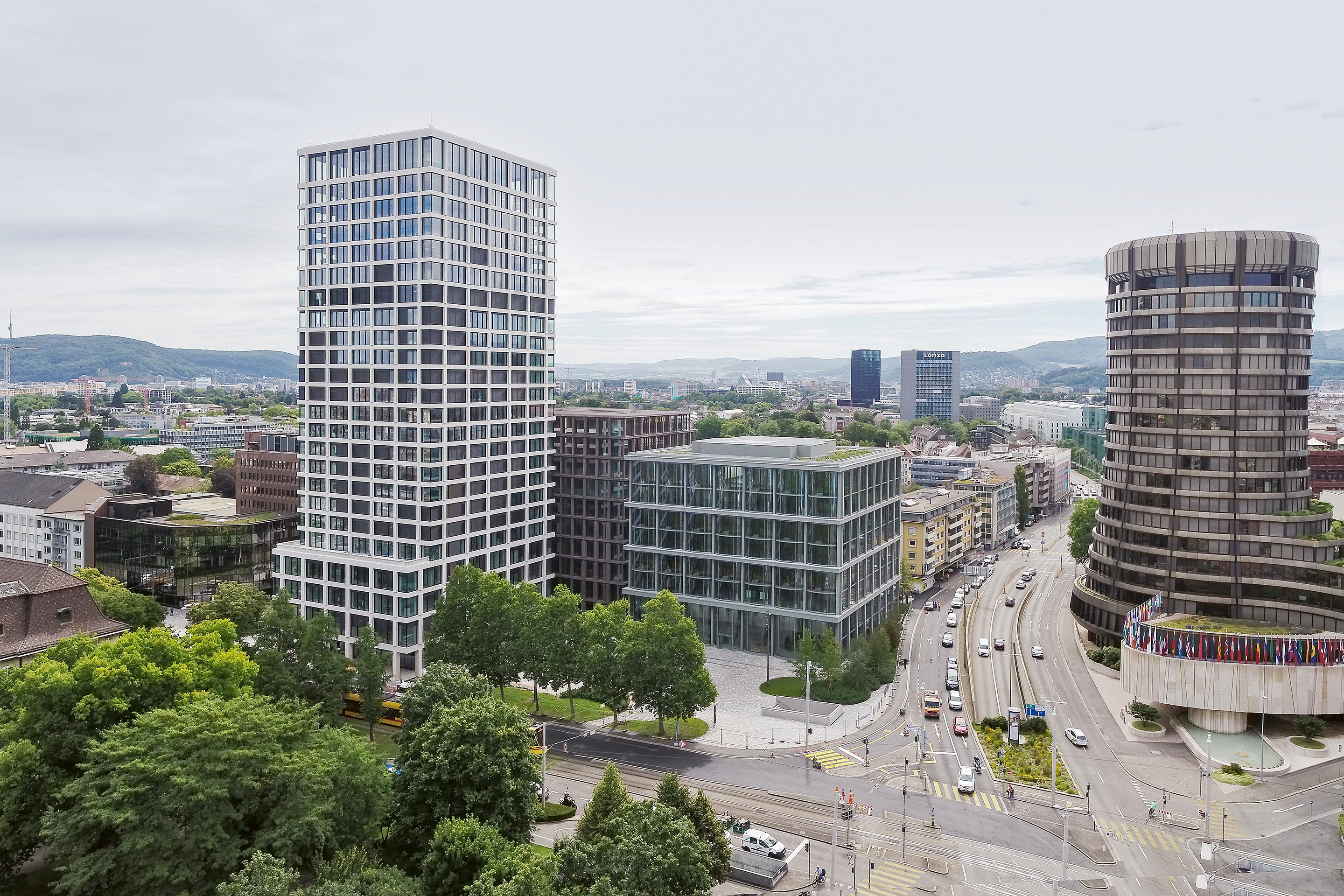 Stadtbildprägend positionieren sich die Basler Versicherungen gegenüber  der Bank für Internationalen Zahlungsausgleich aus den 1970er-Jahren (rechts).