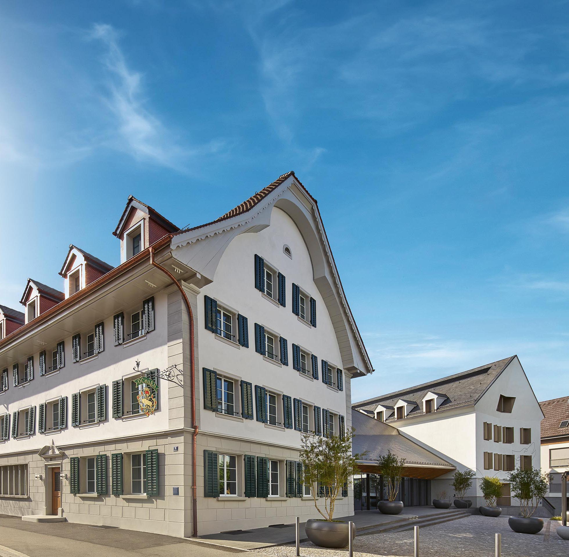 Das neue Ensemble aus Ochsen (links), Verbindungsbau mit Saal und dem Neubau des Hauses Wolf (rechts). Das Sgrafitto  auf der Fassade des Letzteren zeigt einen stilisierten Wolf.