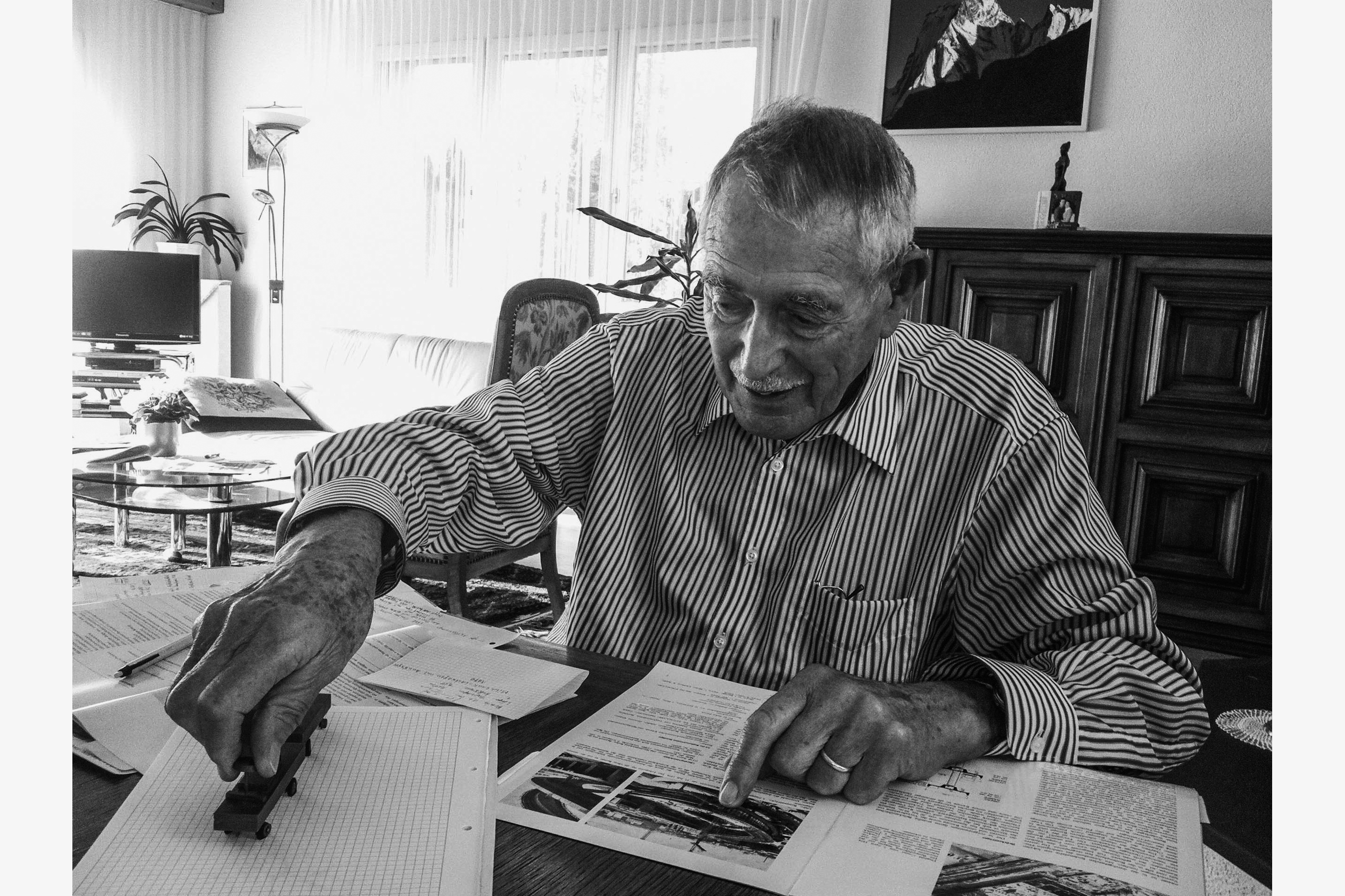 Dialma Jakob Bänziger mit dem legendären Spielzeug-Milchlaster, den er eigens für die Bemessung der Rampe an  der Toni-Molkerei in Zürich fertigen liess. Vor ihm liegt die Ausgabe der «Schweizerischen Bauzeitung» vom 5. Mai 1977.  Darin berichtet er als Autor ausführlich über die Arbeiten zum Neubau.