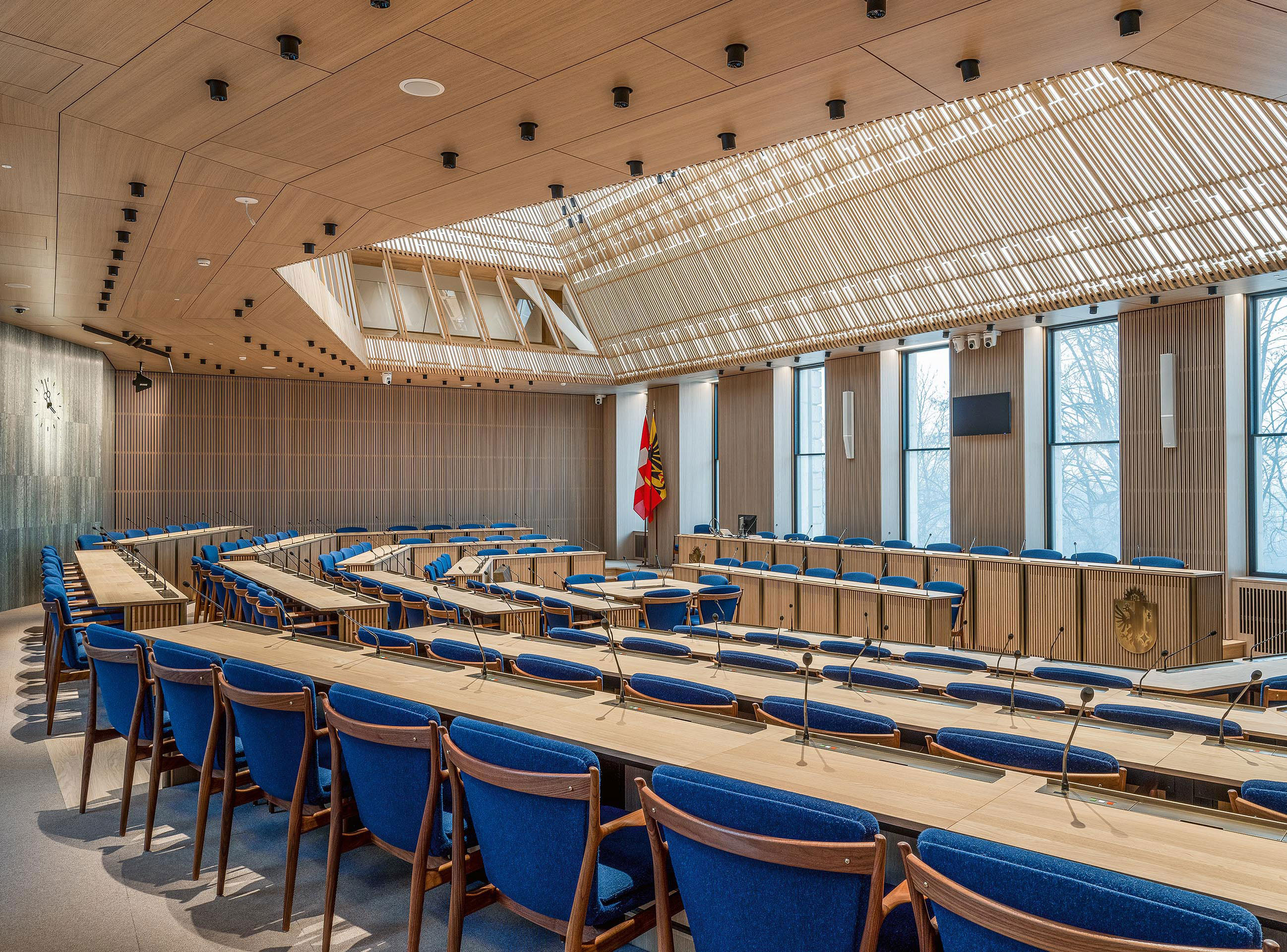 L’ancienne disposition des pupitres en U a cédé la place à un hémicycle «à la française». Les fauteuils sont une réédition exclusive du modèle créé en 1951 par Finn Juhl pour l’ONU à New York.