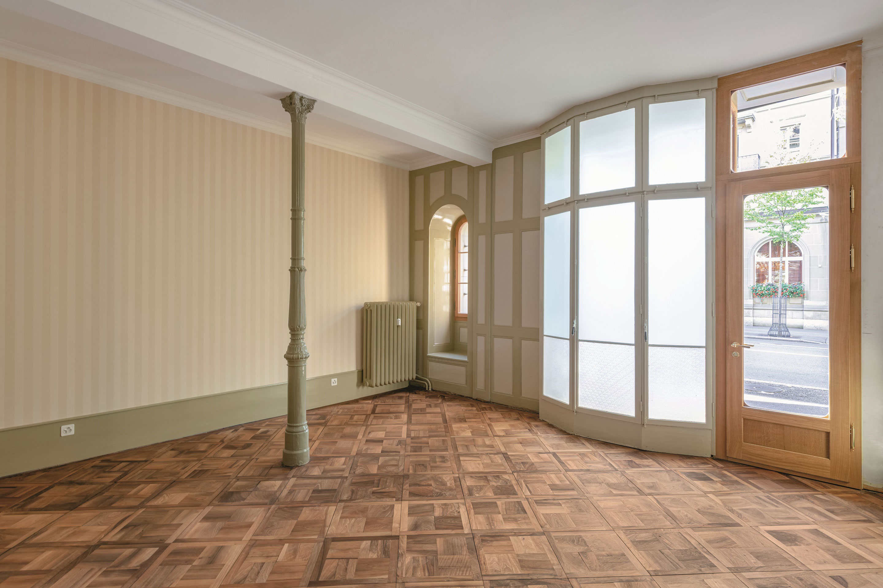 Das Ladenlokal an der Bundesgasse 16 in Bern. Das originale Interieur von 1868 mit vertäfelten Wände, Gusseisensäulen, Dekortapeten und Massivholzparkett wurde wieder hergestellt.
