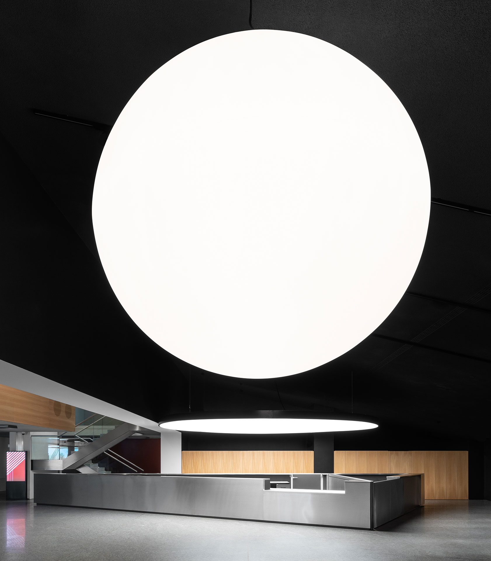 Il nuovo Foyer del LAC a Lugano, 2020 – Vista della nuova area di accoglienza del LAC Lugano. Prospettiva d’insieme, bancone reception, sistema d’illuminazione (lampada sfera + lampada disco).