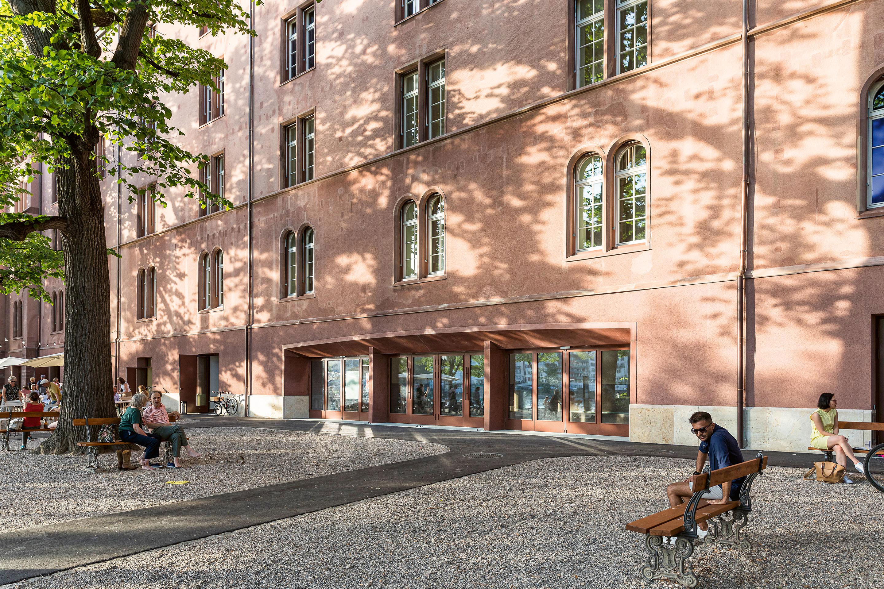 Basler Toskana: Der Vorplatz und die rot verputzte Schaufassade zum Rhein fangen Passanten und die Abendsonne ein. Die Öffnung des Bauwerks mit einem neuen Segmentbogen hingegen fällt etwas brav aus – auch aus Rücksicht aufs Baudenkmal.