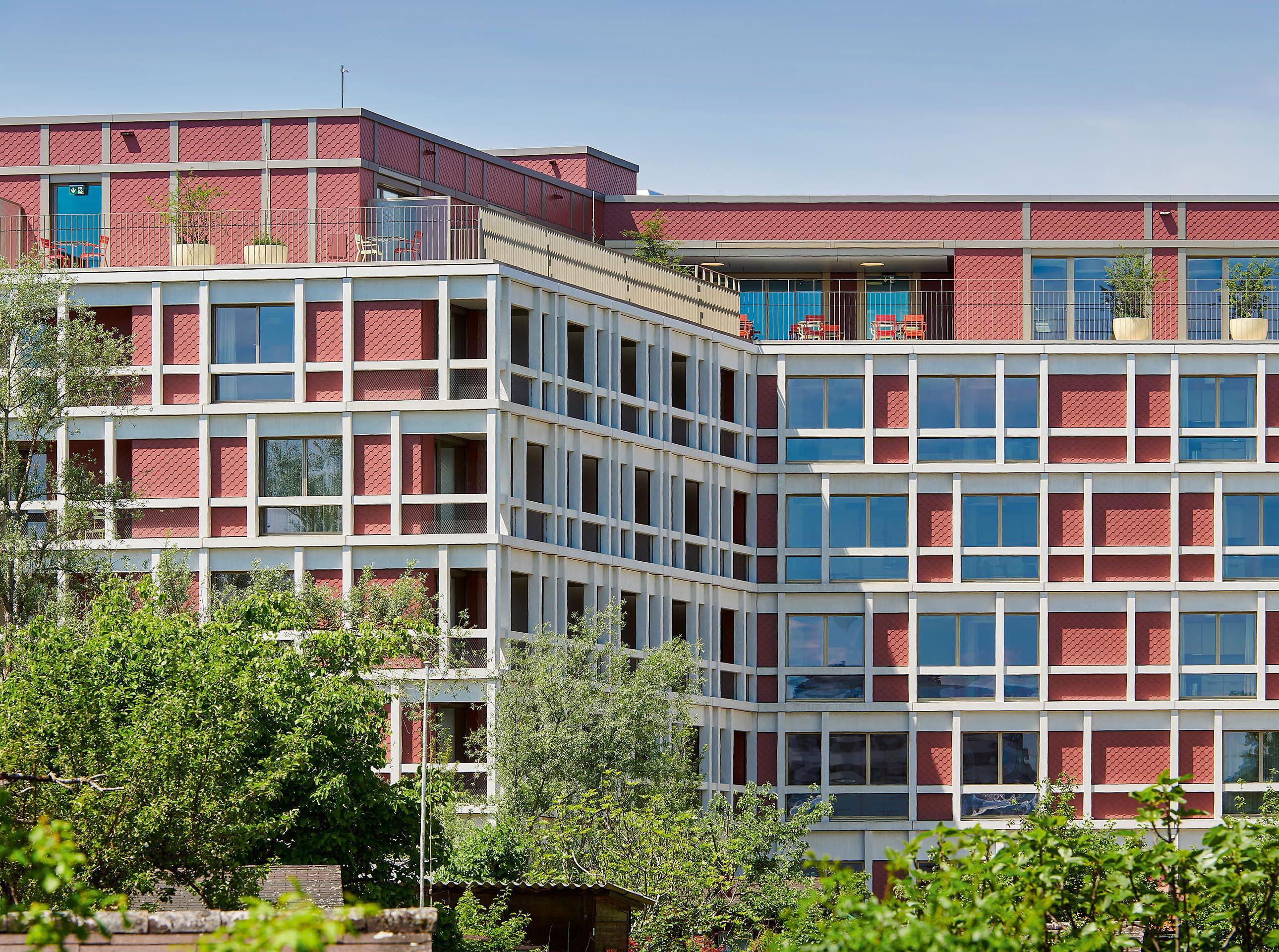 Der Bau mit seiner feinen, textil wirkenden Eternitfassade hebt sich von ­Modeströmungen in der Fassadengestaltung ab und schafft gerade dadurch eine charaktervolle Verbindung zur modernen Architektur.
