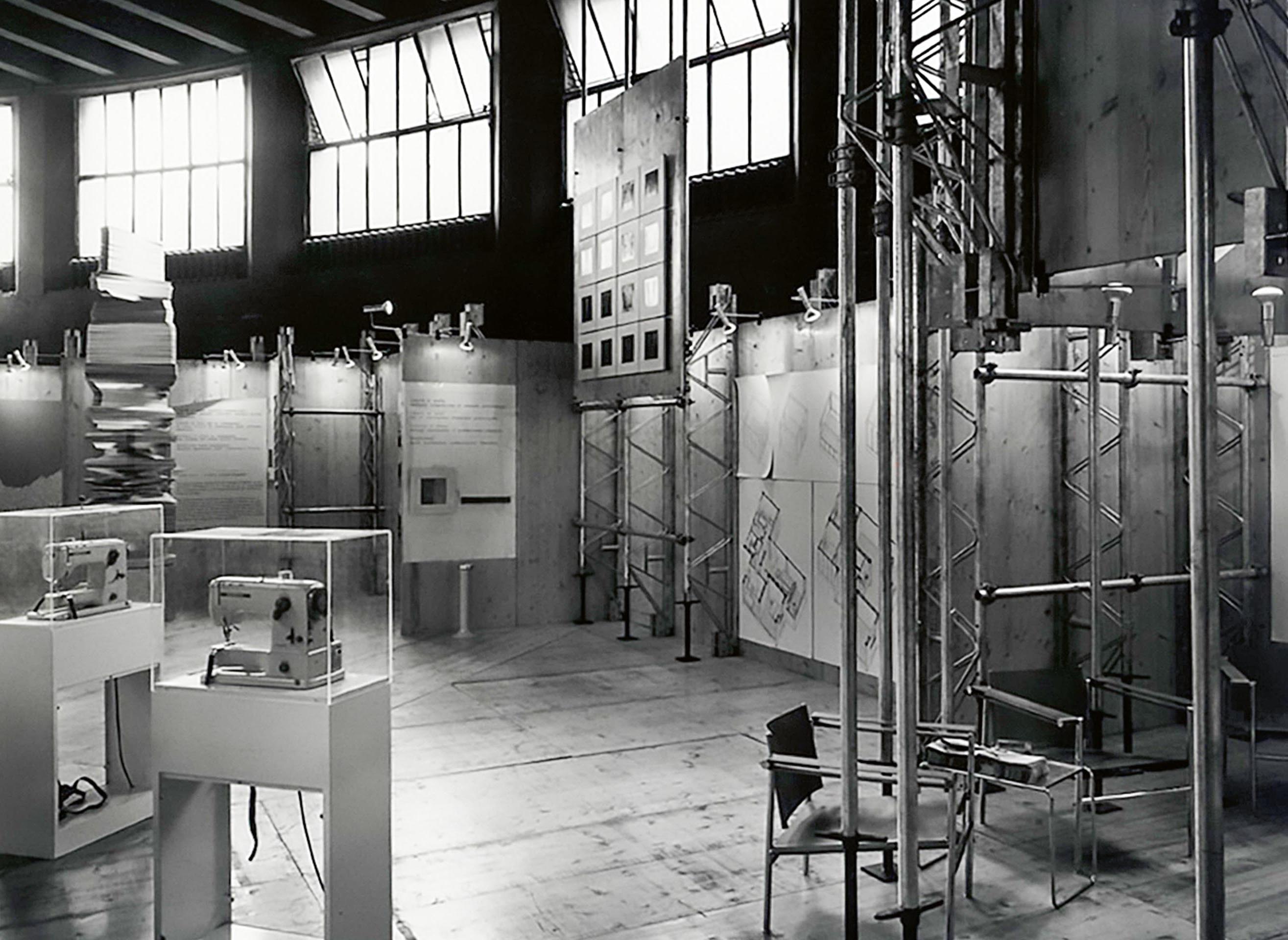 Allestimento della sezione svizzera, a cura di F. Schwarz, R. Gutmann, F. Gloor e L. Burckhardt. In primo piano le macchine da cucire; sullo sfondo l’opera Carro 64 di Karl Gerstner.