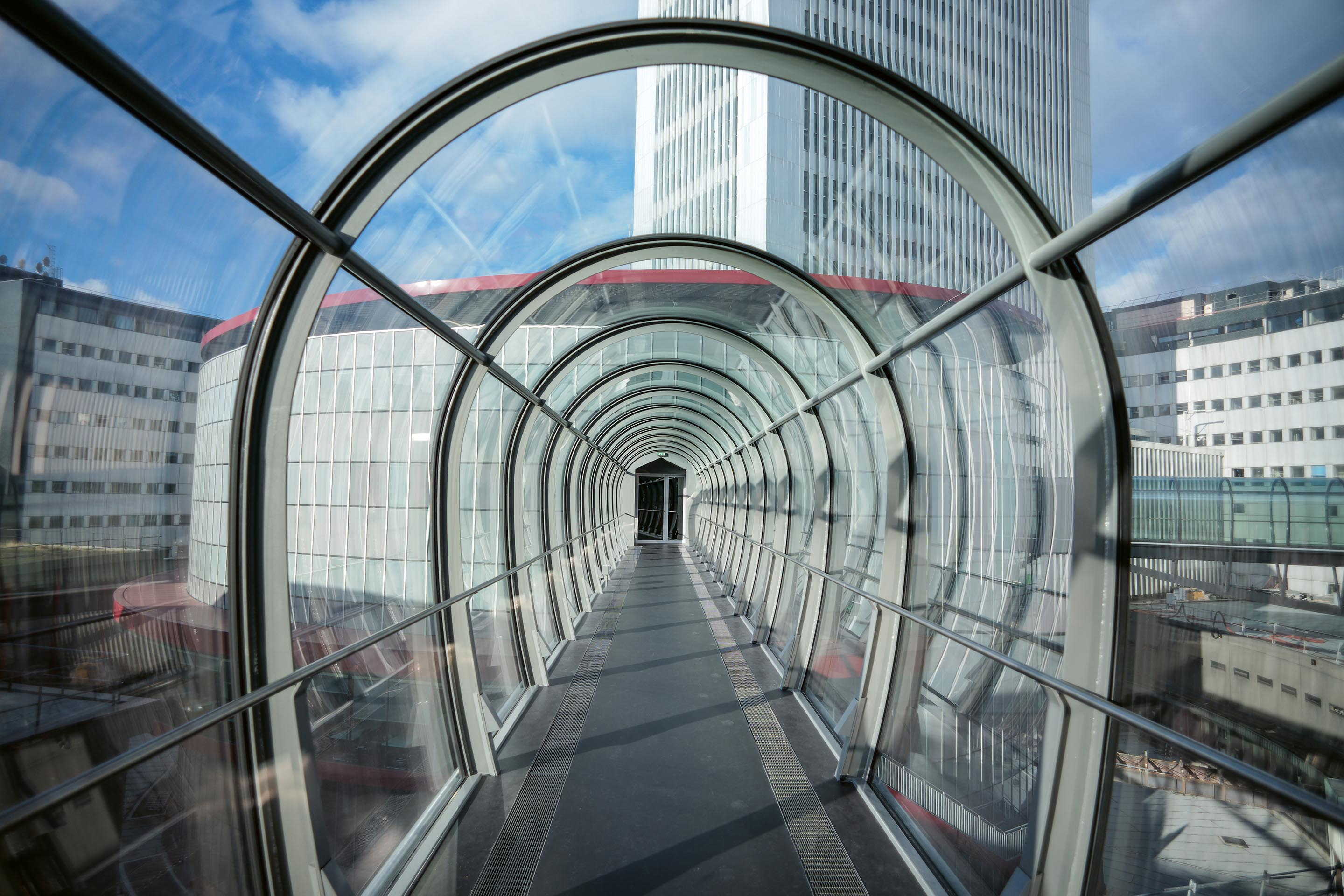 Vier neue Passarellen führen in der fünften Etage vom inneren zum äusseren Ring und kürzen so die Wege für das Personal ab, denn früher mussten die Angestellten von einem Ring über das Erdgeschoss durch den Hof in den anderen Ring gehen.