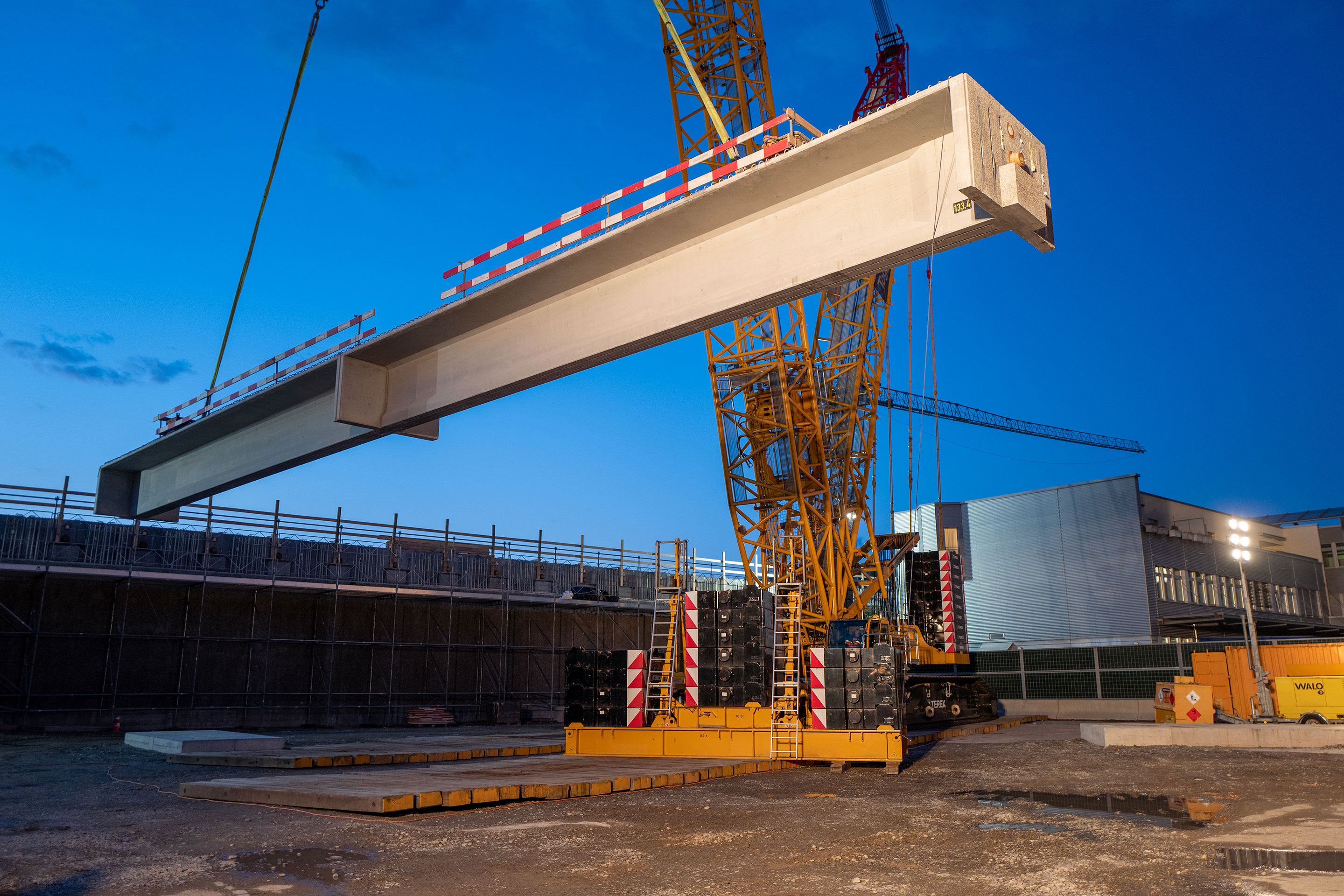 Der erste Träger der Nachtschicht hängt am 650-Tonnen-Raupenkran für den Einbau bereit.