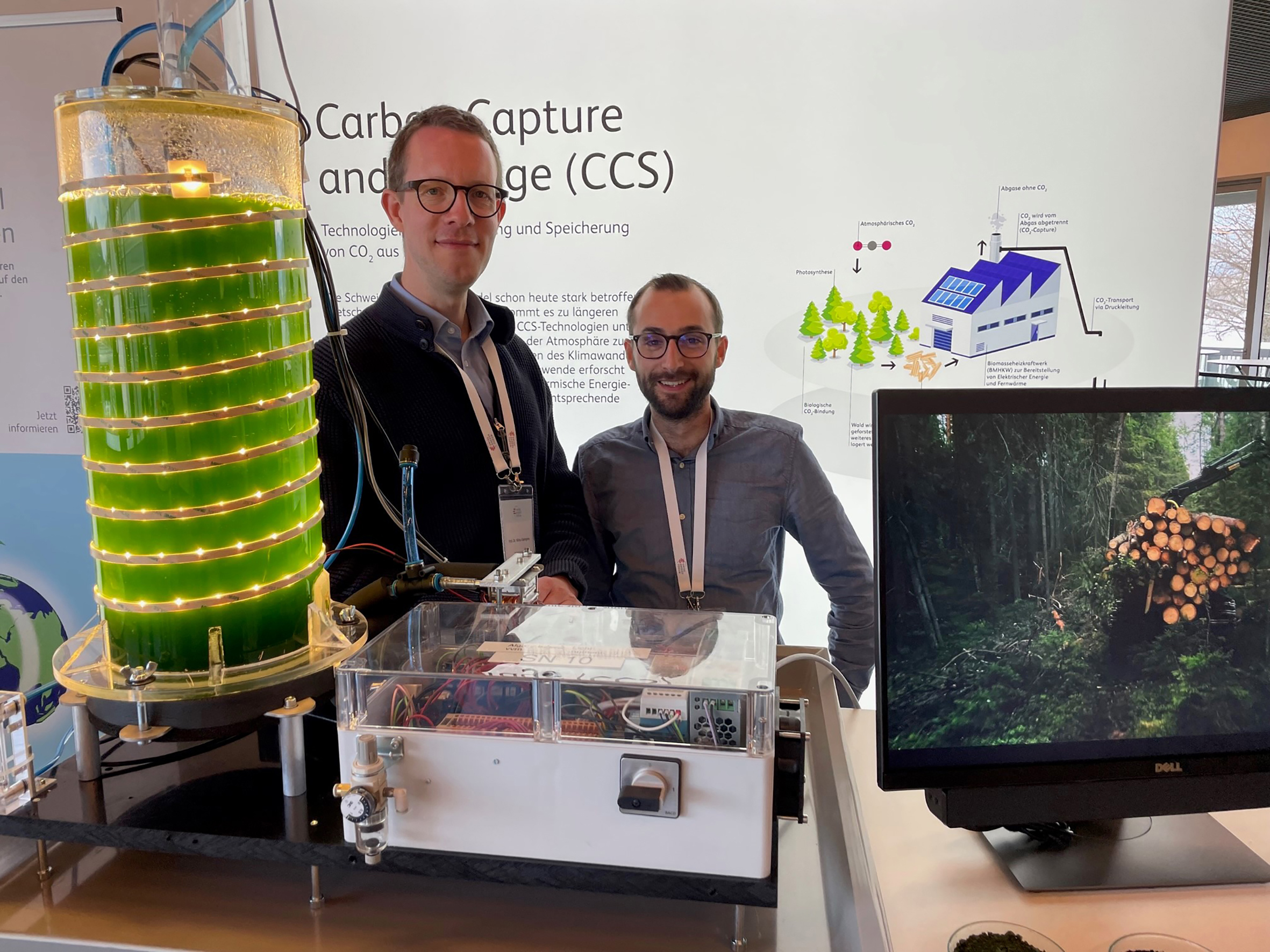 Prof. Dr. Mirko Kleingries, Leiter des Kompetenzzentrums Thermische Energiesysteme und Verfahrenstechnik der Hochschule Luzern und Masterabsolvent Reto Tamburini präsentieren einen Photobioreaktor am Swiss Energy Forum. © HSLU