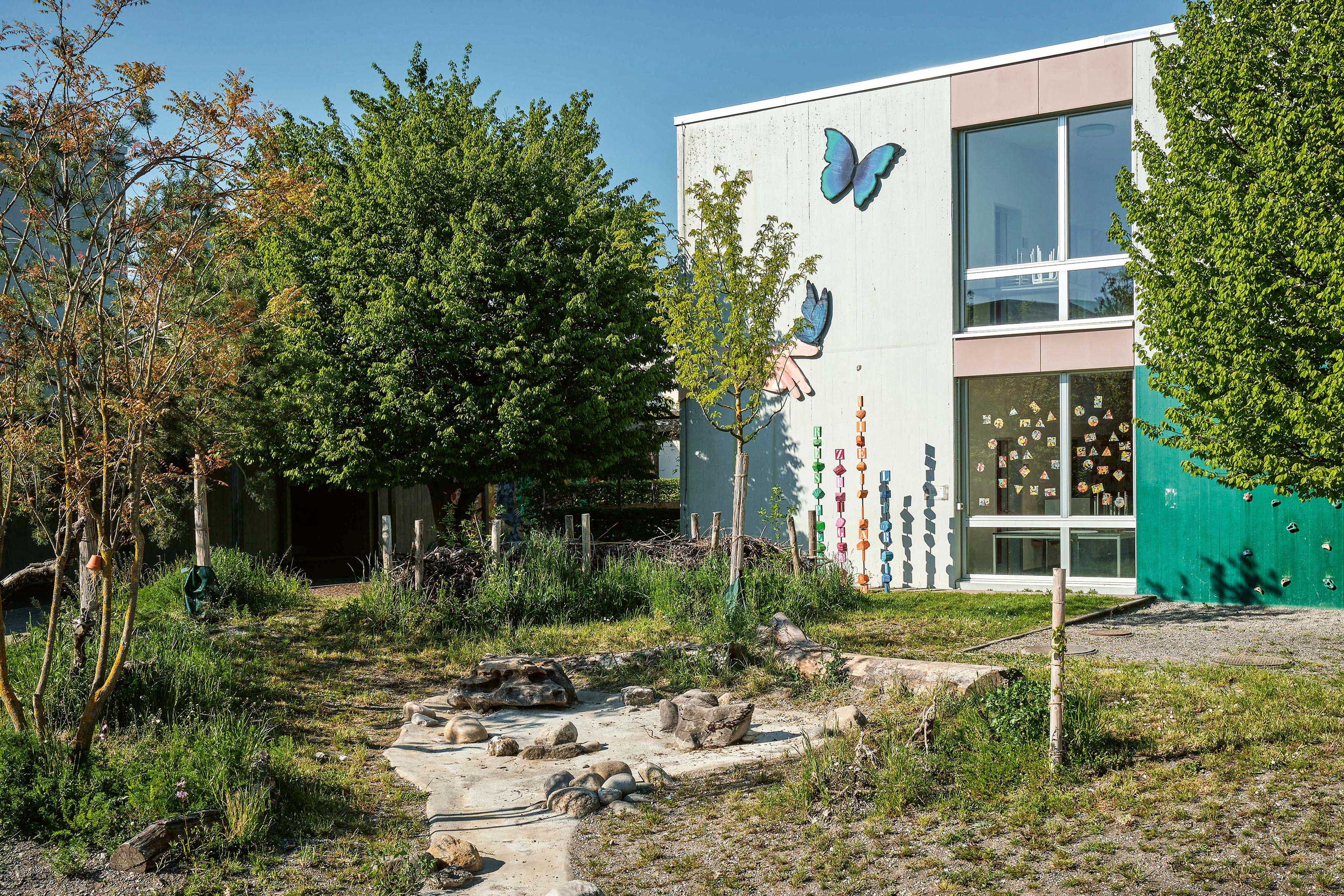 Die Entsiegelung schafft Platz für neue Pflanzen und Bäume: Die Kletterwand an der Fassade und ein altes Wasserspiel wurden in die neue Gestaltung integriert.