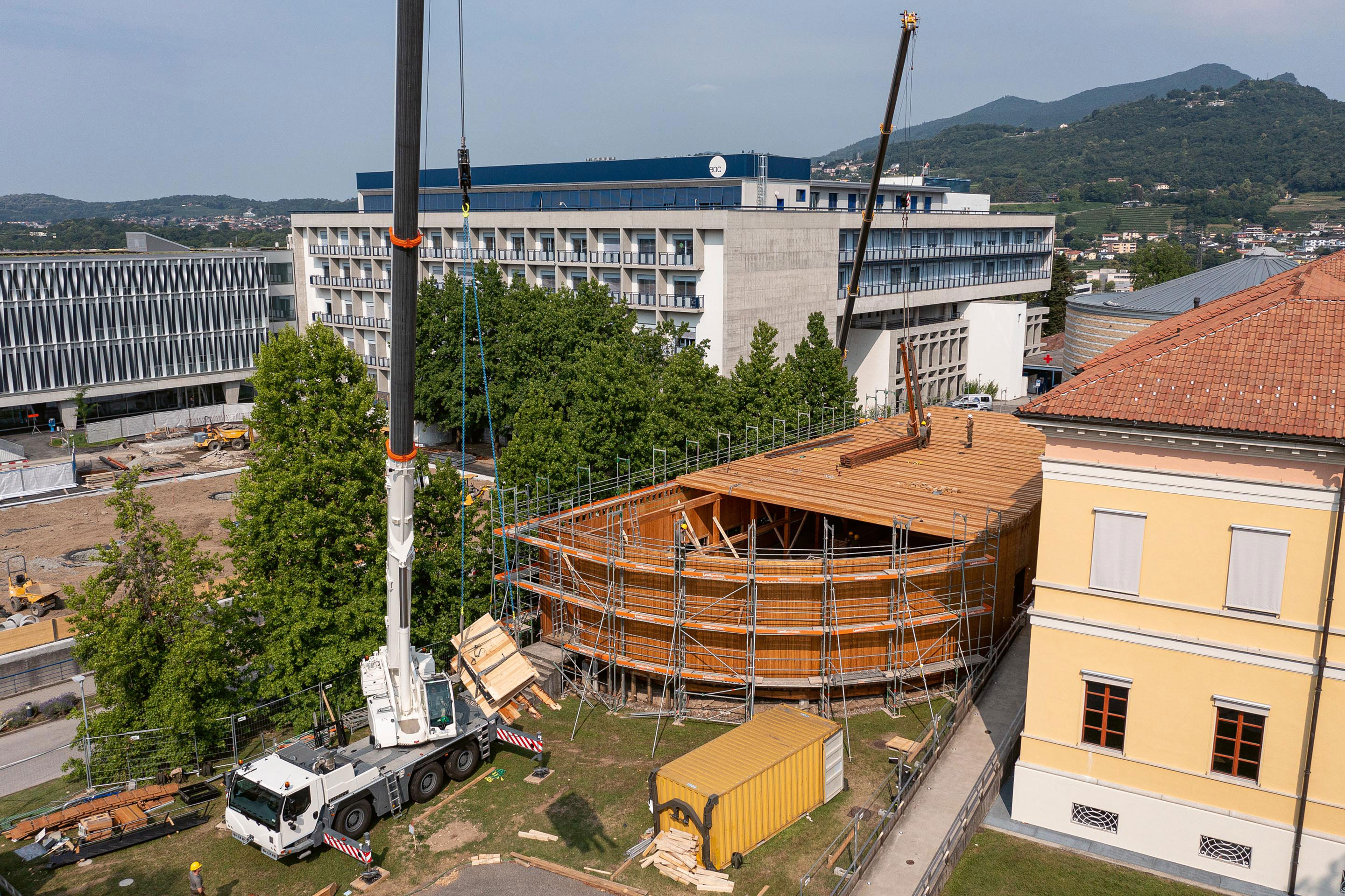La sequenza di  immagini racconta la metamorfosi dell’edificio: da aula polivalente provvisoria a biblioteca AAM a Mendrisio, lo smontaggio a cura di armasuisse e infine la trasformazione in palestra a Genestrerio.