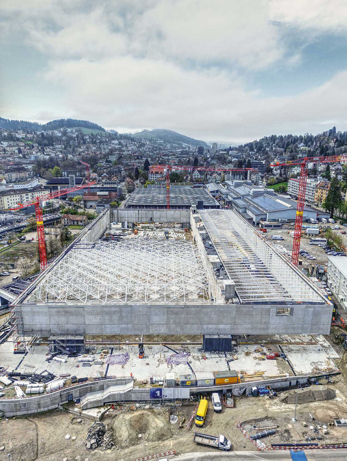 Die Halle während des Baus der Stahldächer. Vorne sichtbar zwei der Fundamentpunkte (dunkler Beton) und die ­beeindruckenden Auskragungen der Betonwände. Die Verbindungselemente der Wände zum Boden hin fehlen noch.