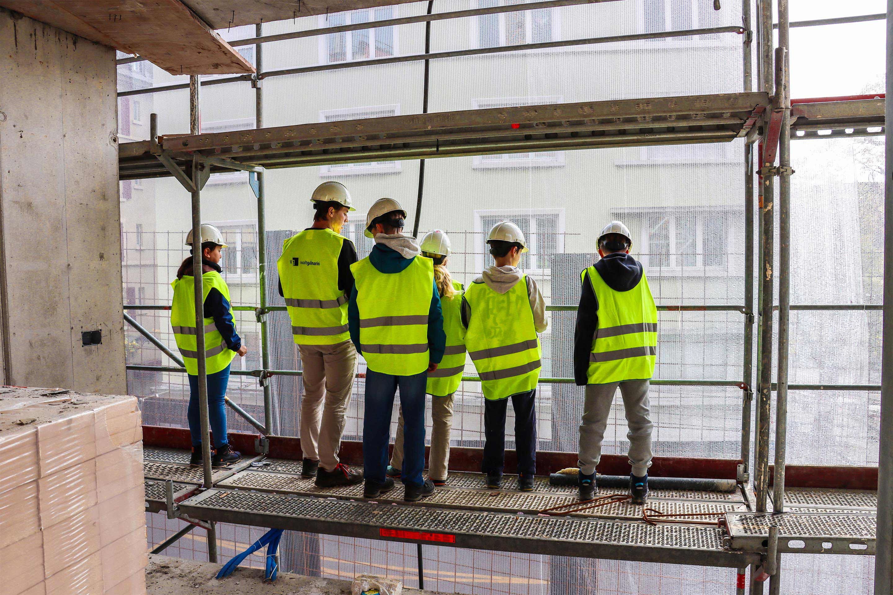 Auf der Baustelle «Hegibachstrasse» sind Gerüste rundherum aufgebaut, die zum Rohbau hin den Abstand von 30 cm einhalten müssen. Das Loch darf wegen den Suva-Vorschriften keinen Millimeter grösser sein.  Das feine Netz vor dem Gerüst schützt die Fussgängerinnen und Fussgänger auf dem Trottoir und die Elektrobusse auf der Strasse vor herunterfallenden Baustellenwerkzeugen oder Staub.