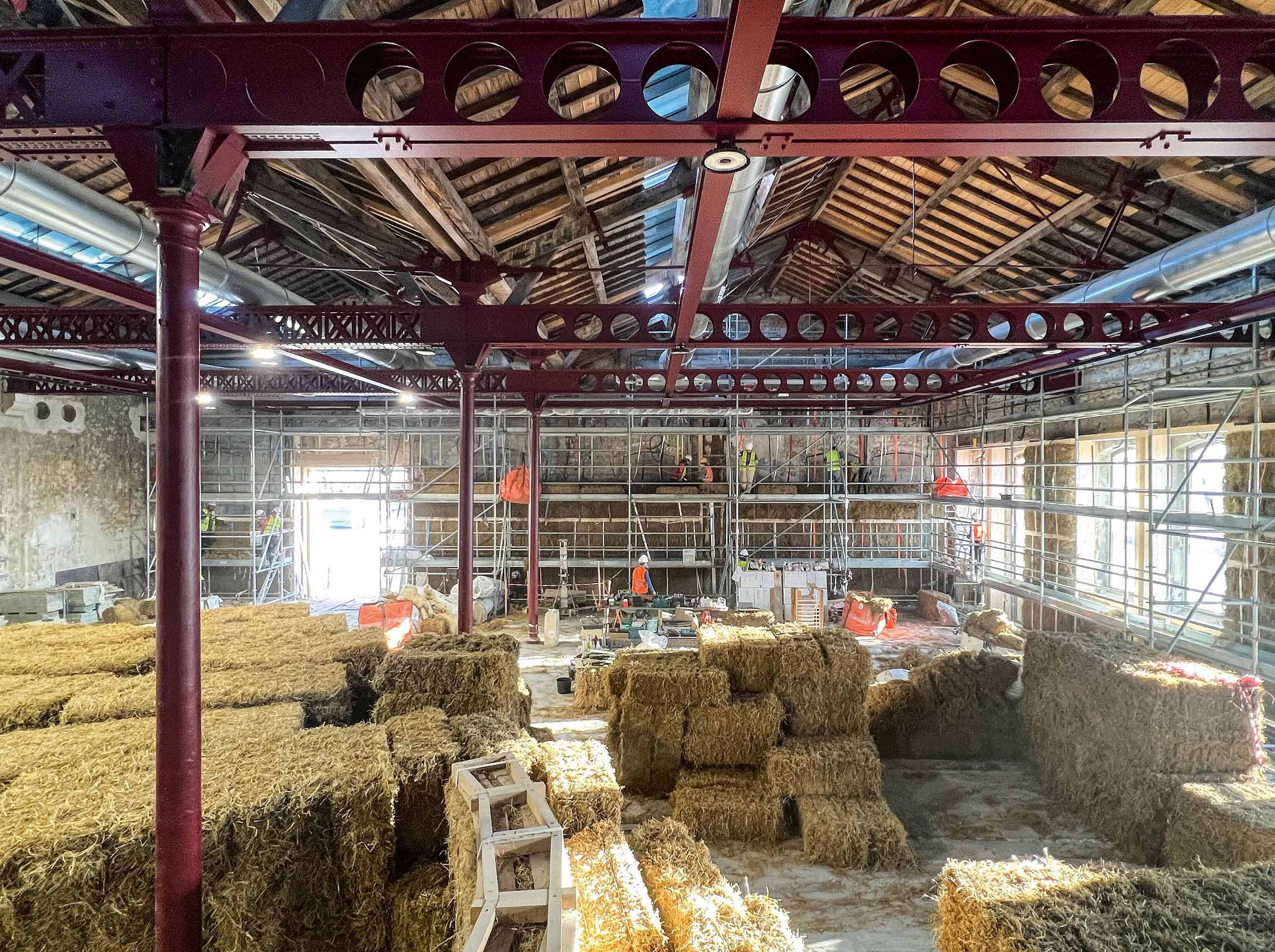 Isolation en paille par l’intérieur d'un hangar ferroviaire en pierre devenu salle de conférence, 400 m2 de paille en trois semaines (hors enduits) – Nebraska et Corrèze Menuiseries: Nebraska pour Atelier Luma – Arles 2023, France.