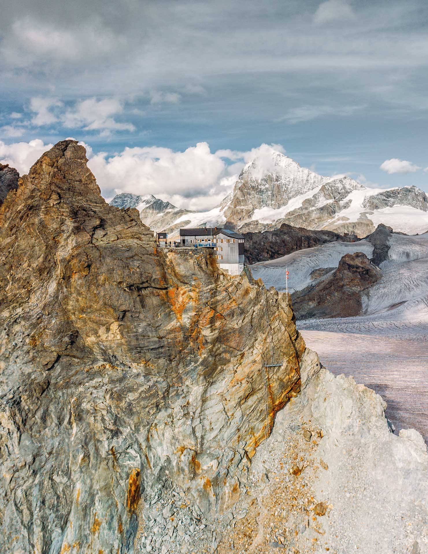 La cabane de Bertol, reconstruite en 1975 par Jakob Eschenmoser, se situe sur une arête rocheuse suspendue à l’origine entre deux versants glaciaires.