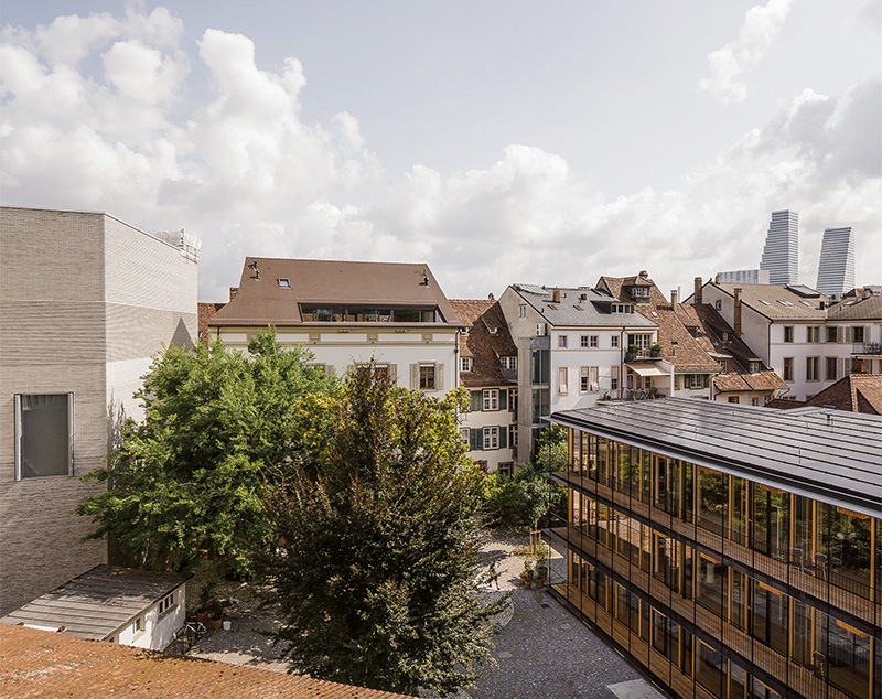 Herzog  &amp; de Meuron wollen mit ihrem Neubau an den ursprünglichen Charakter anknüpfen: Hinter den repräsentativen Vorder­häusern standen traditionell schuppenartige Hofbauten, die einfach und aus Holz ausgeführt waren. Hinter dem Neubau des Kunstmuseums von Christ &amp; Gantenbein (links im Bild) liegt der stark frequentierte St. Alban-Graben.