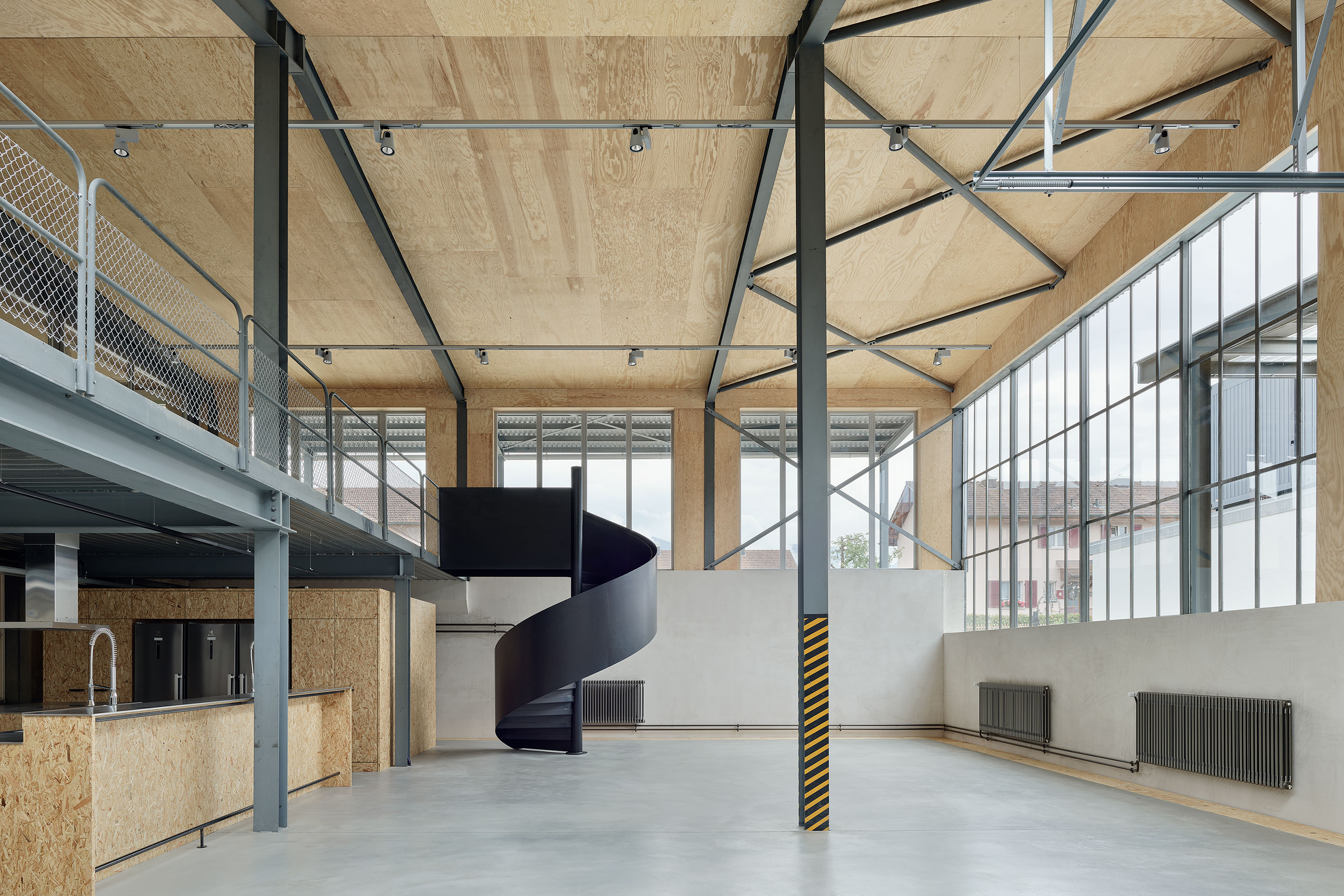 Die Cafeteria mit der Wendeltreppe zu den Büroräumen ist das neue Herzstück der ehemaligen Fabrik.