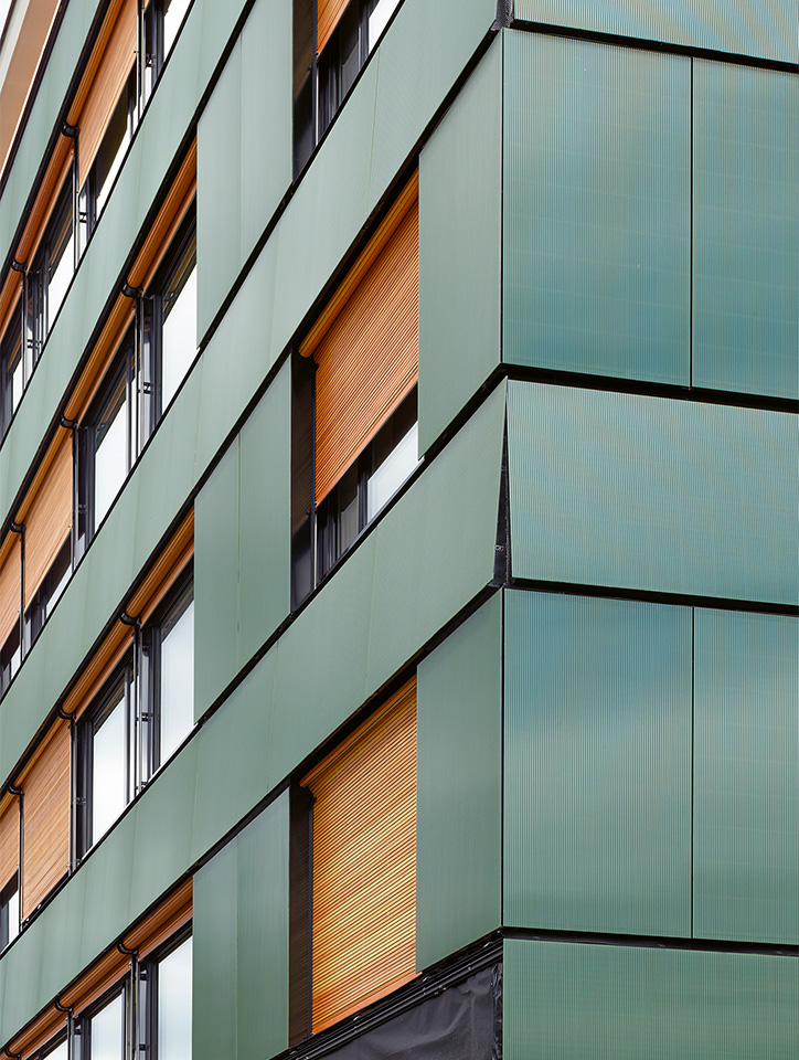 An der Ecke zeigt sich der raffinierte Kniff: Die Architekten liessen die Panels im Brüstungsbereich schräg montieren.