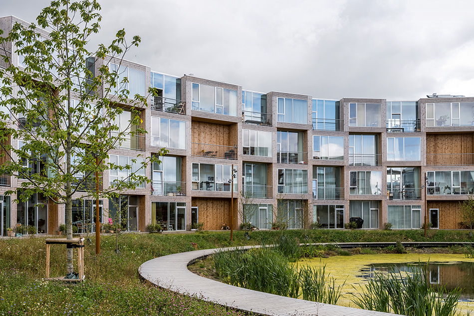 La construction à partir de modules préfabriqués de grande dimension connaît de nouveaux records ces dernières années. Particulièrement économique, elle produit généralement des espaces génériques. L’agence danoise BIG a construit sa réputation en élaborant toutes sortes de propositions pour briser la monotonie de la construction modulaire, notamment des logements abordables comme le projet Dortheavej (Copenhague, 2018) ou, ici, à Aarhus.