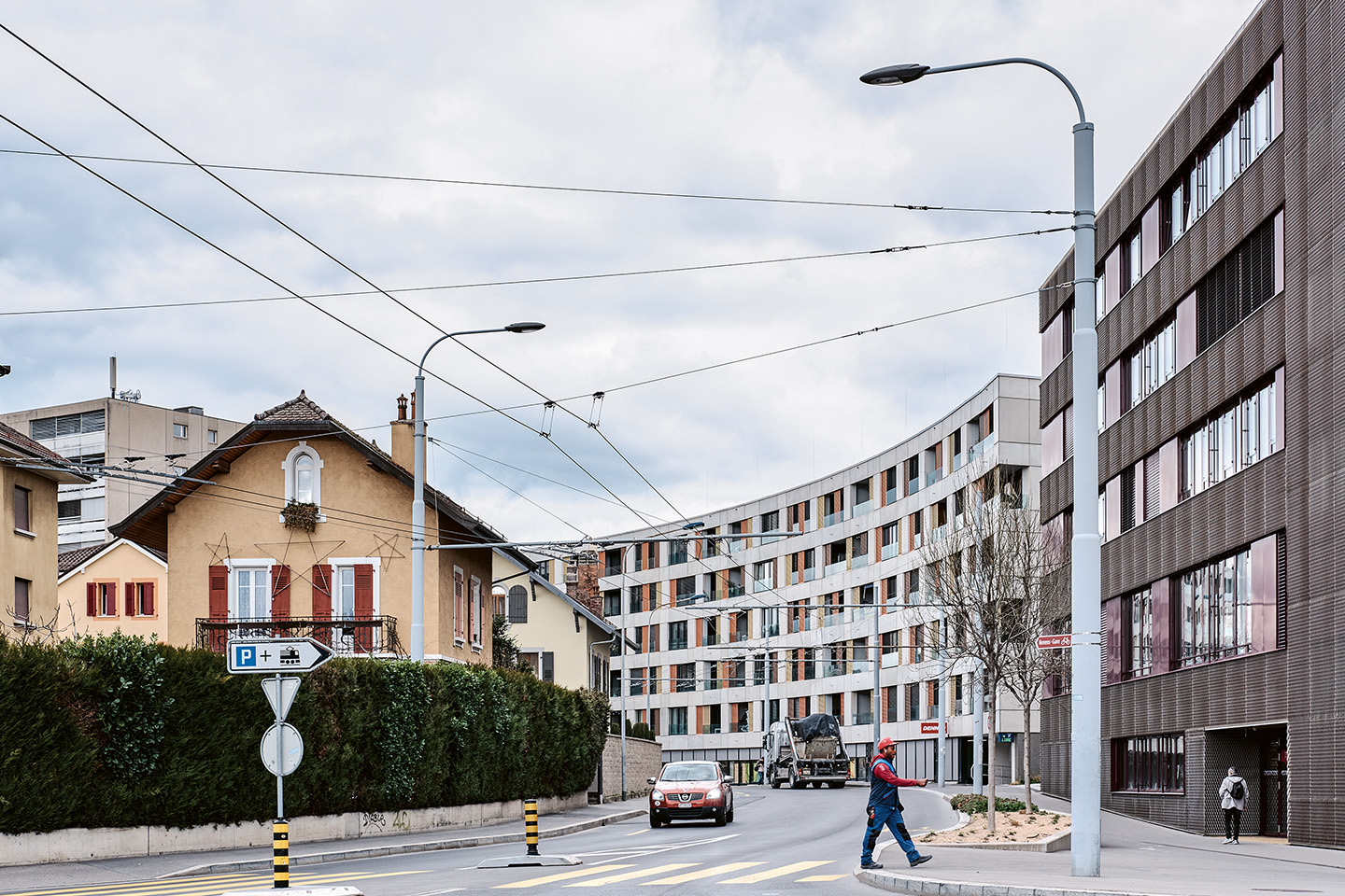 Renens en transition, paysage du développement vers l’intérieur. Rue du Simplon. À gauche, des maisons du début du siècle dernier; à droite, l’ancienne friche industrielle des CFF reconvertie en quartier mixte, avec le Gymnase de Renens, livré en 2016 et le Parc du Simplon, livré en 2022.