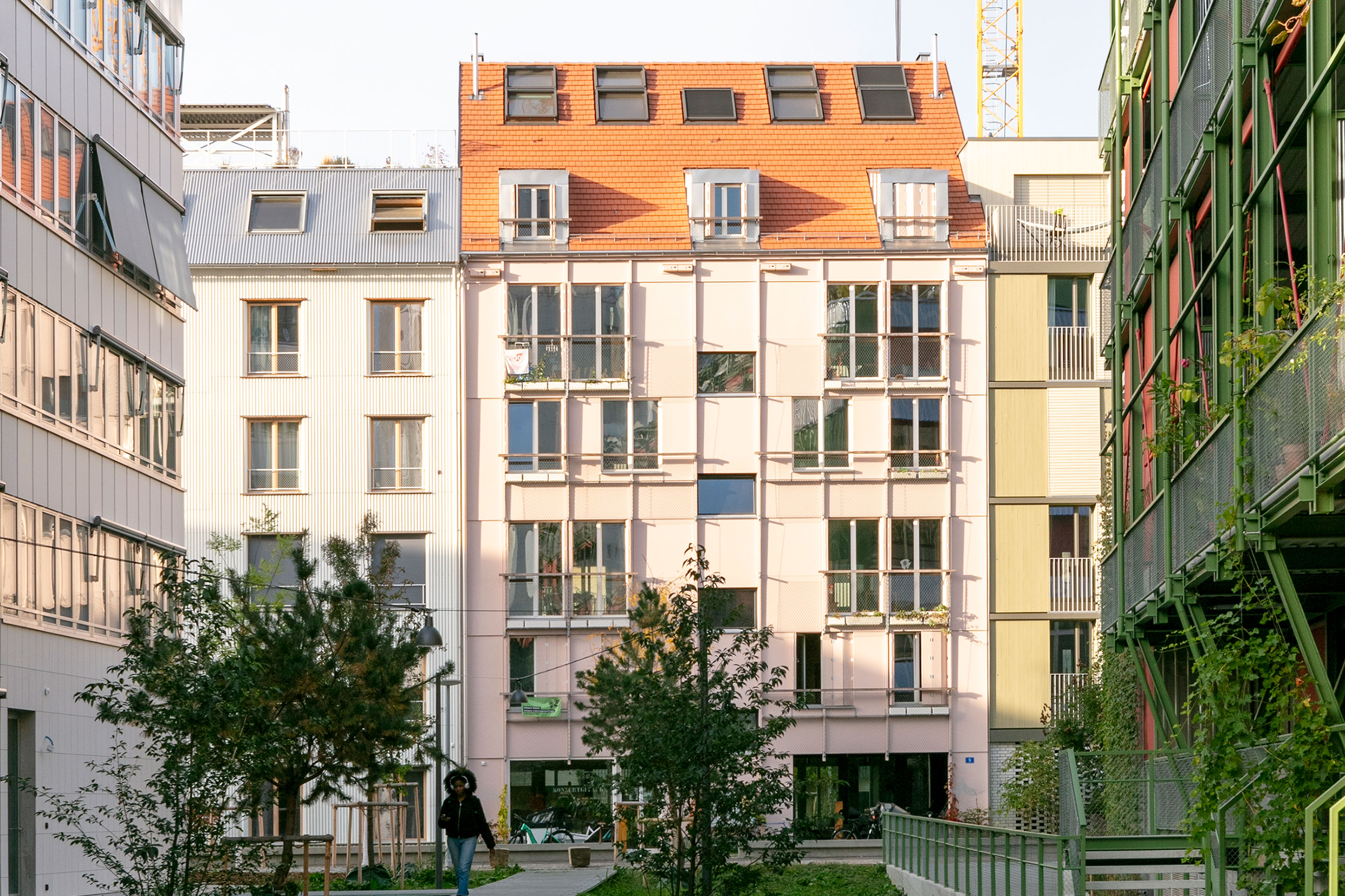 Das Wohnhaus «Stadtkind» mit seiner Fassadenverkleidung aus rosa ­Dreischichtplatten reiht sich punkto Materialisierung und Gestaltung gut in die Nachbarschaft des Lysbüchel-Areals ein.
