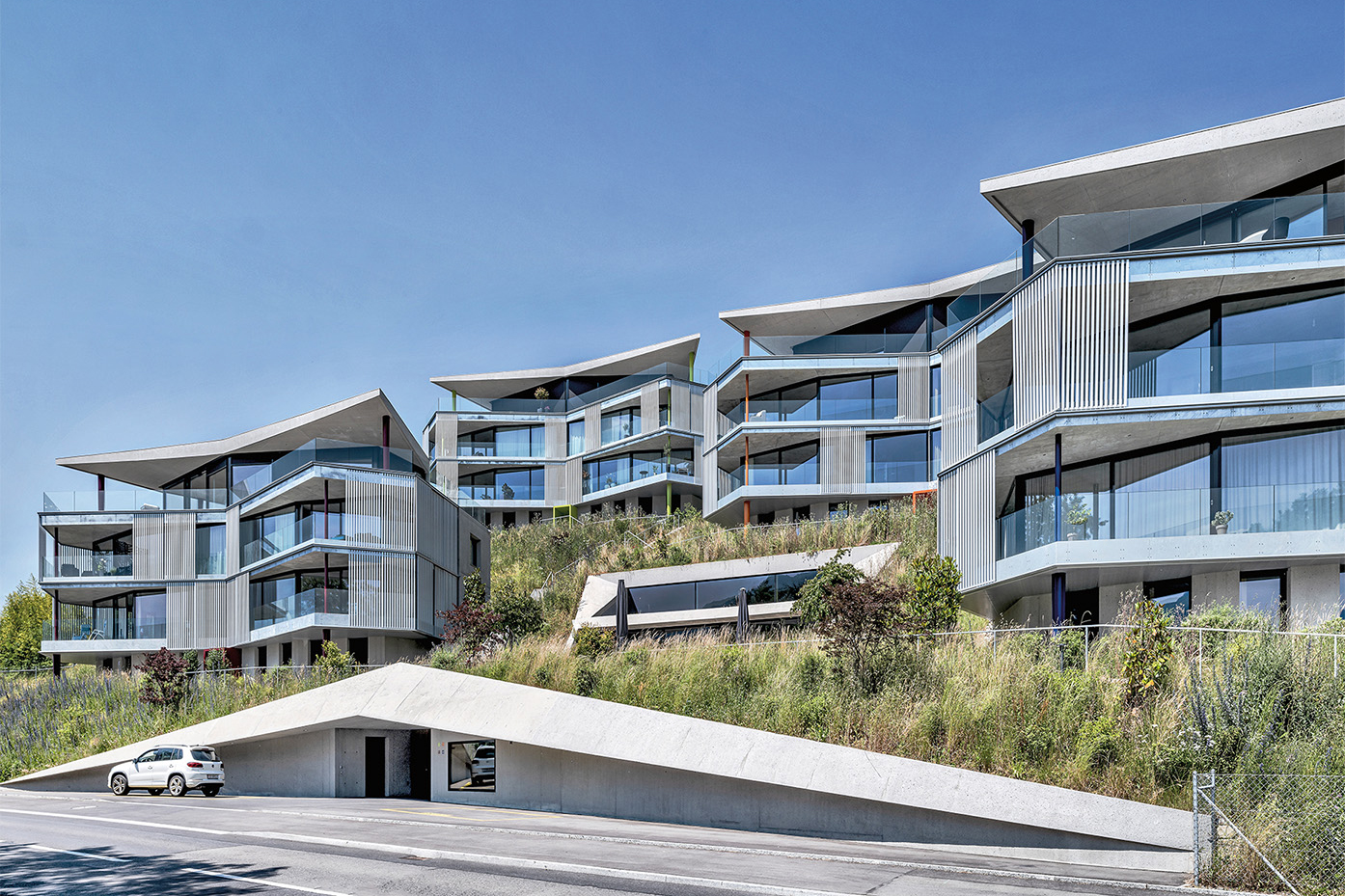 Das Ensemble «Residenz Rigiblick»: Oberirdisch sichtbar sind die vier schmetterlingsförmigen Punktbauten, der Einschnitt mit der vor der Lounge liegenden Terrasse sowie der Eingang zu den Verbindungstunneln.
