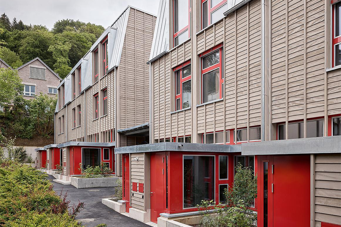 Die für junge Familien konzipierten  Reihenhäuser von EMI Architekt*innen am Stadtrand von Baden sind Holz-Beton-Hybride.