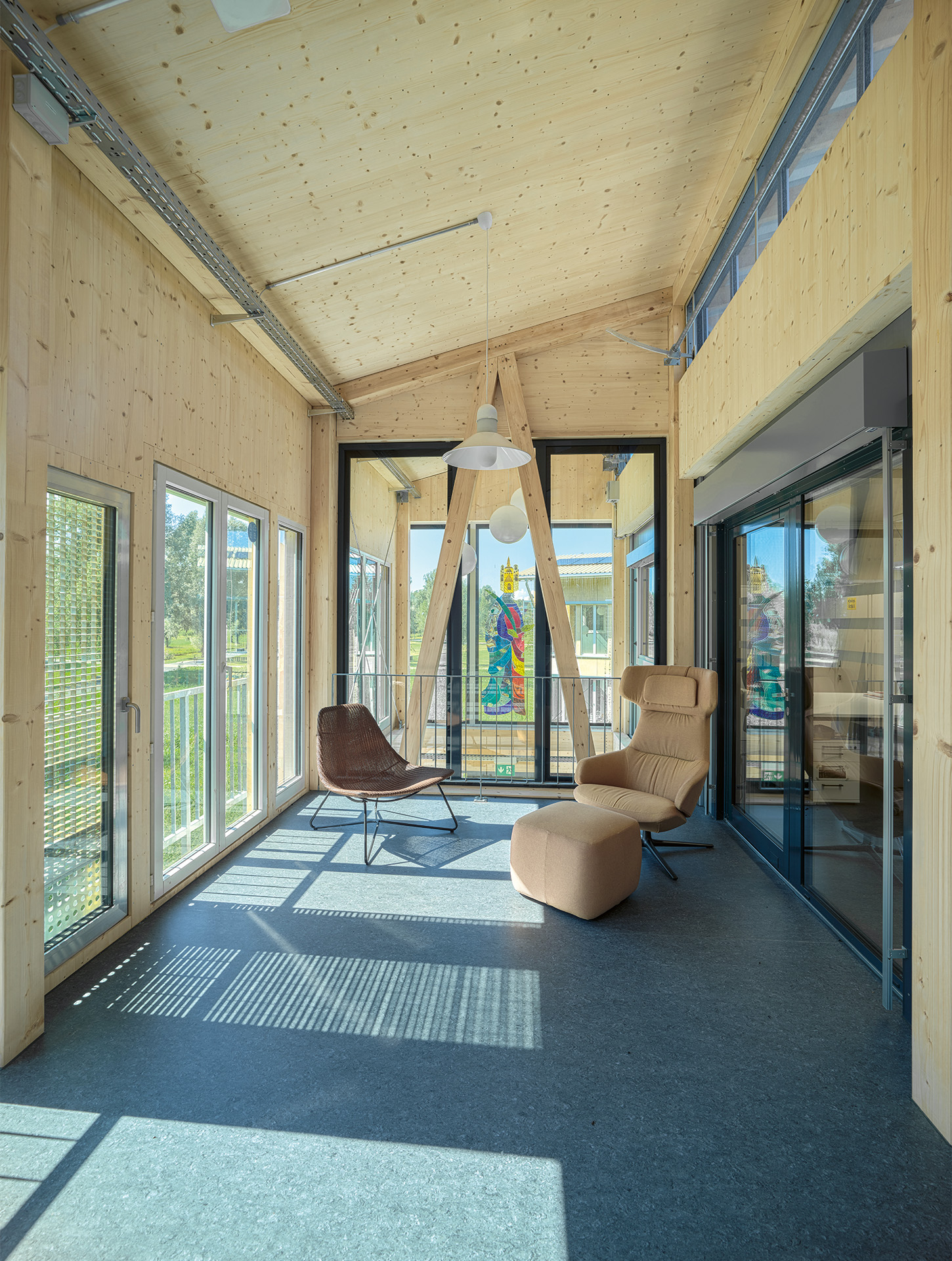 La nouvelle structure en bois reprend le rythme des conteneurs et intègre les différents formats de fenêtres. En arrière-plan, la mosaïque de verre trône au-dessus de l’espace aérien.