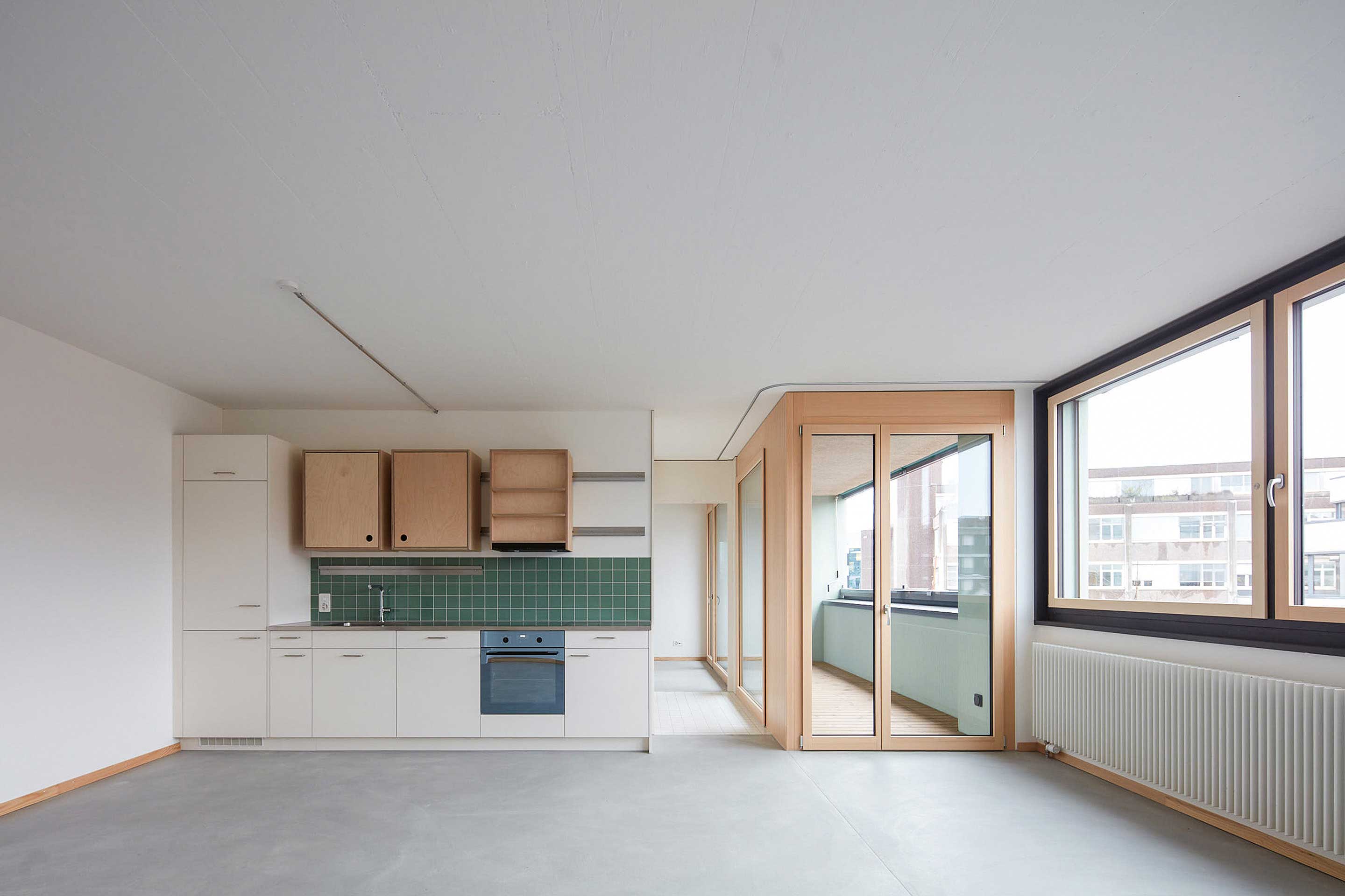 Les appartements s’orientent horizontalement le long des fenêtres en bande ; les armoires supérieures de cuisine développées par BHSF sont coulissantes et extensibles.