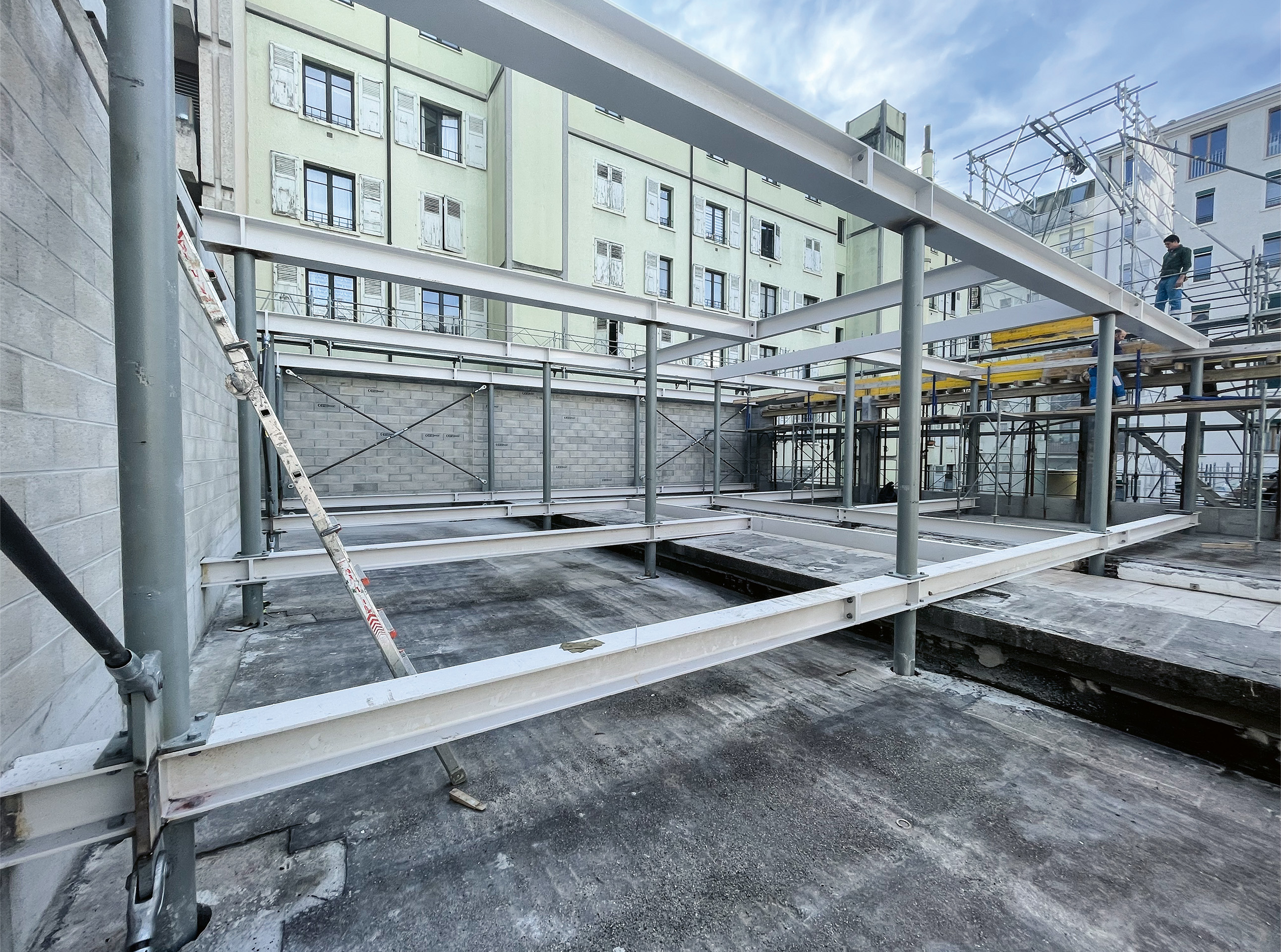 Vue du chantier. Comme le bâtiment existant ne peut supporter la surcharge d’un étage supplémentaire et la végétalisation de la toiture, architectes et ingénieurs imaginent un endosquelette métallique traversant l’existant, ancré sur une série de micropieux.