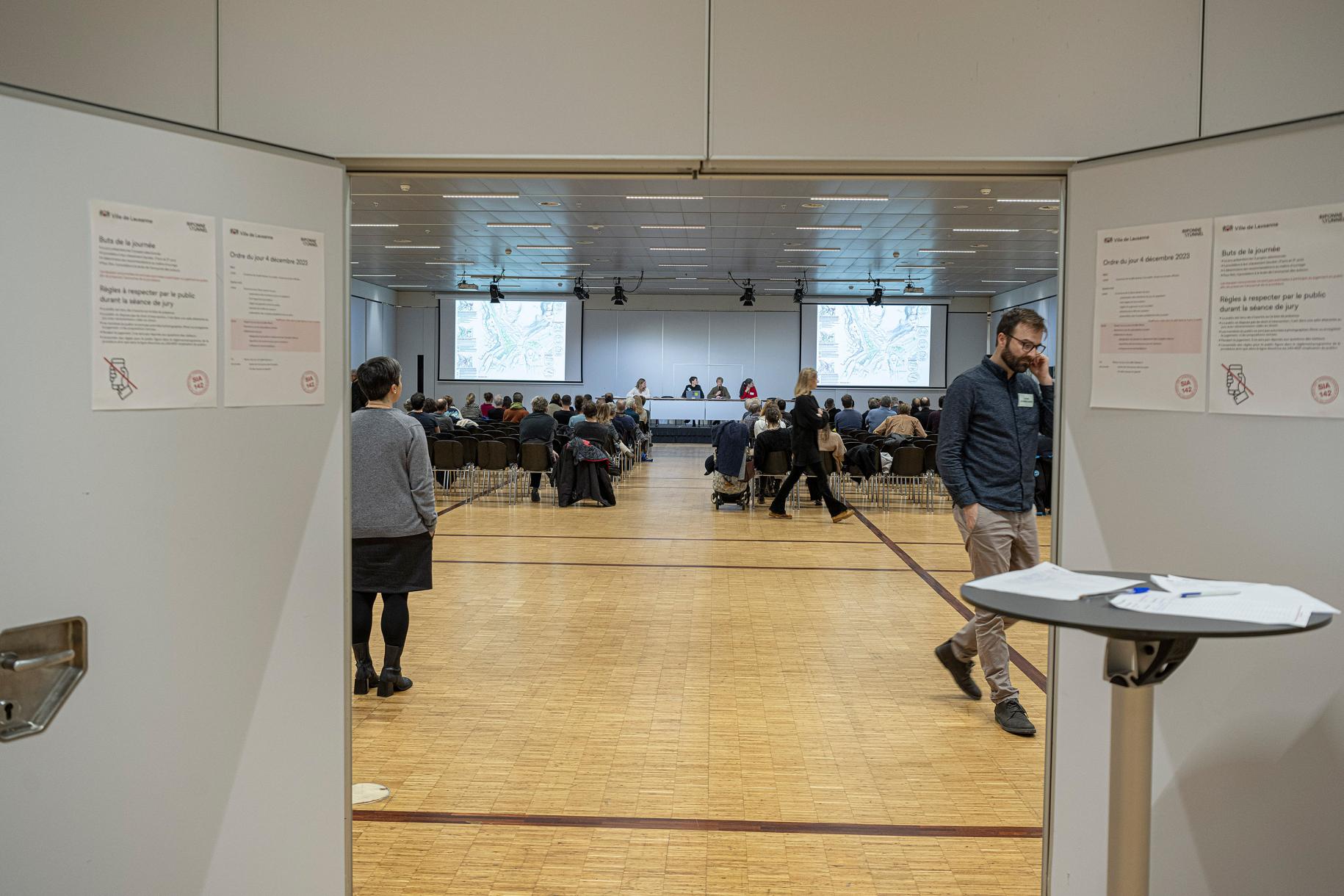 At the entrance to the public room, a reminder of the SIA rules. The guideline on public involvement prohibits teams from attending jury debates. When it was drafted, this guideline probably did not envisage the use of separate rooms and the possibility of rebroadcasting. We can imagine that at the time, the judging brought together all the parties involved in the same room - separated by a simple rope - and that this proximity added pressure on the jury, which could potentially recognise the faces of colle