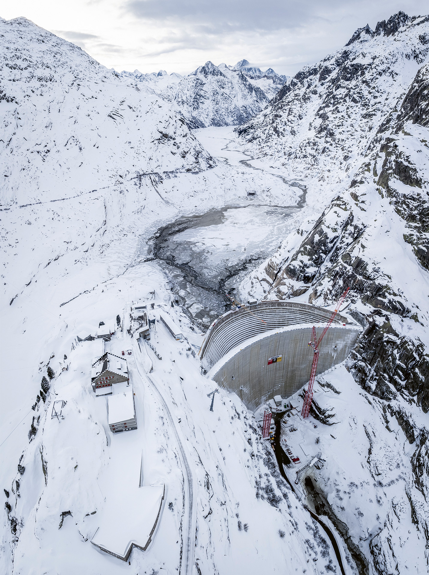 Les deux barrages de Spitallamm devant le Grimselsee vidangé avec, à gauche sur le Nollen, l’hospice du Grimsel et son téléphérique.