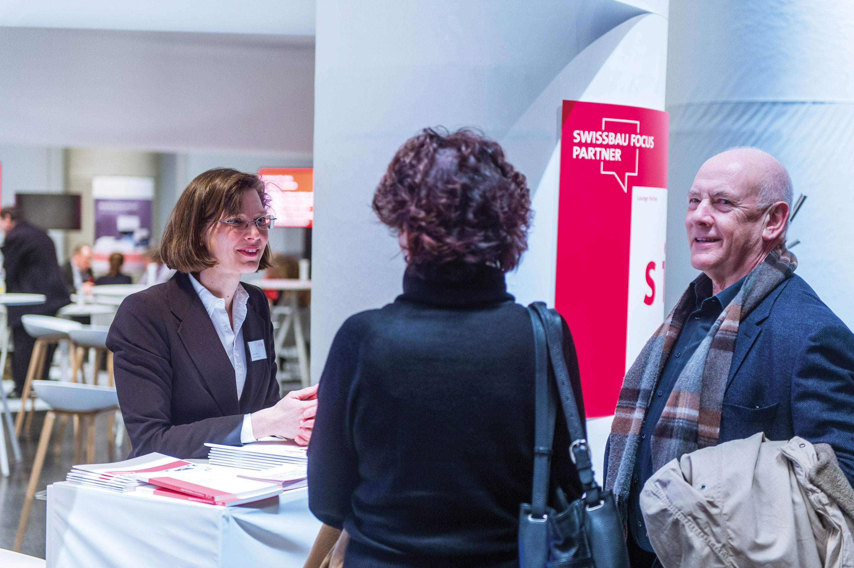 Kai Halbach, collaboratrice de la SIA, en conversation avec des visiteurs du stand SIA.