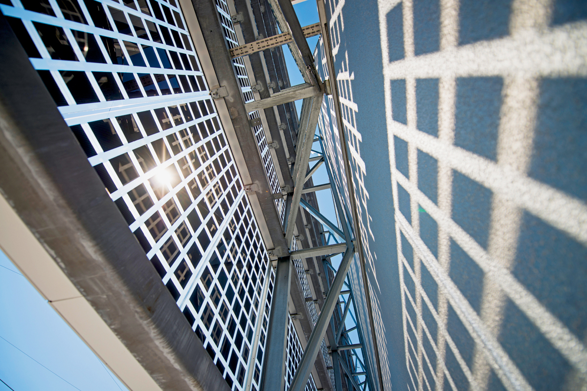 Die neue, vor die Südwand gesetzte PV-Fassade ist mit einer Metallstruktur befestigt. Die Wand ist silbrig gestrichen und reflektiert das Licht, das zwischen den quadratischen PV-Zellen durch das Sicherheitsglas dringt. Die vom CSEM entwickelten bifazialen PV-Zellen nutzen dieses reflektierte Licht, was ihren Wirkungsgrad um geschätzte 10 %–20 % erhöht.