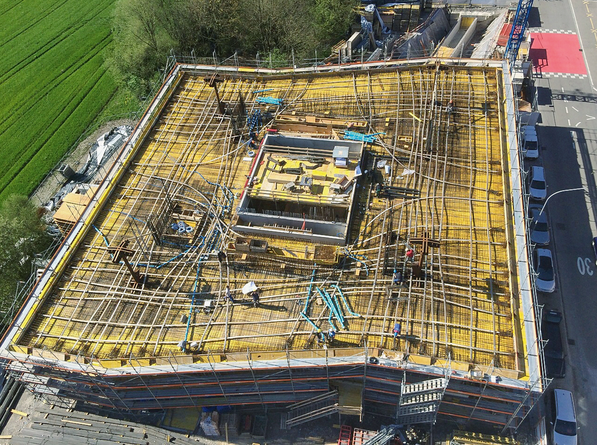 Bis zu 9.5 m statische Auskragung, Nutzlasten von 12.0 kN/m2 und 60 cm starke Geschossdecken: Die Vorspannung der Decke mit Flachkabeln war unumgänglich, und die Spannkabel mussten in ihrer Lage und Höhe minutiös auf der Baustelle verlegt werden.