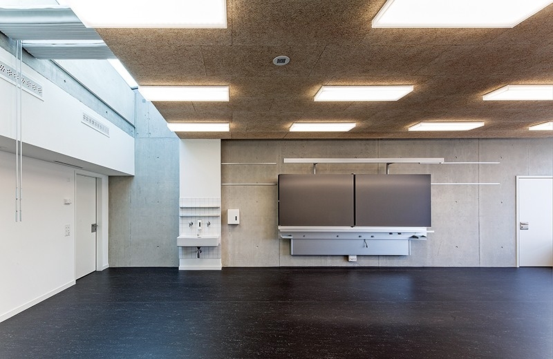 Klassenzimmer im 2. OG: Im Inneren stellt sich das Schulhaus Blumenfeld als komplexes Gefüge mit einer Vielzahl an unterschiedlichen Räumen, Zonen und Nischen dar, die zeitgemässe und flexible Lern- und Unterrichtsformen ausserhalb der Klassenzimmer ermöglichen. Die Schulzimmer stehen quer zur Fassade und werden zusätzlich über den Innenhof von zwei Seiten belichtet. Die Kindergartenräume im ersten Obergeschoss sind über vier Meter hoch, damit das Tageslicht bis in die hinterste Ecke dringen kann.