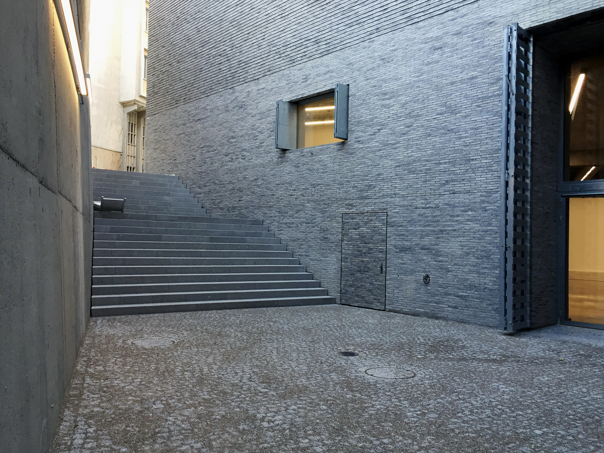 Fassade aus Ziegelmauerwerk: Die Aussenwand des Erweiterungsbaus des Kunstmuseums Basel ist zweischalig. Sie ist nicht wie üblich vorgehängt, sondern ein eigenständiges und selbsttragendes Bauteil. Das Ziegelmauerwerk mit einem 1 oder 2 cm tiefen Relief (Versatz) erscheint aus der Nähe rau und handgefertigt, aus der Weitsicht einheitlich und edel.