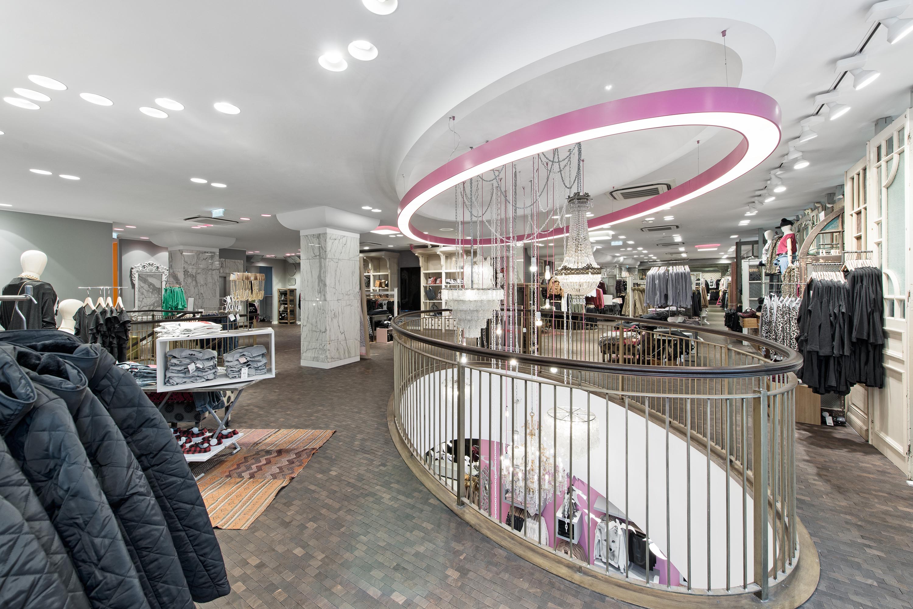 Im Tally Weijl-Shop in Wien nimmt eine übergrosse Glorious-Leuchte von Prolicht die Form der Galeriebrüstung auf.