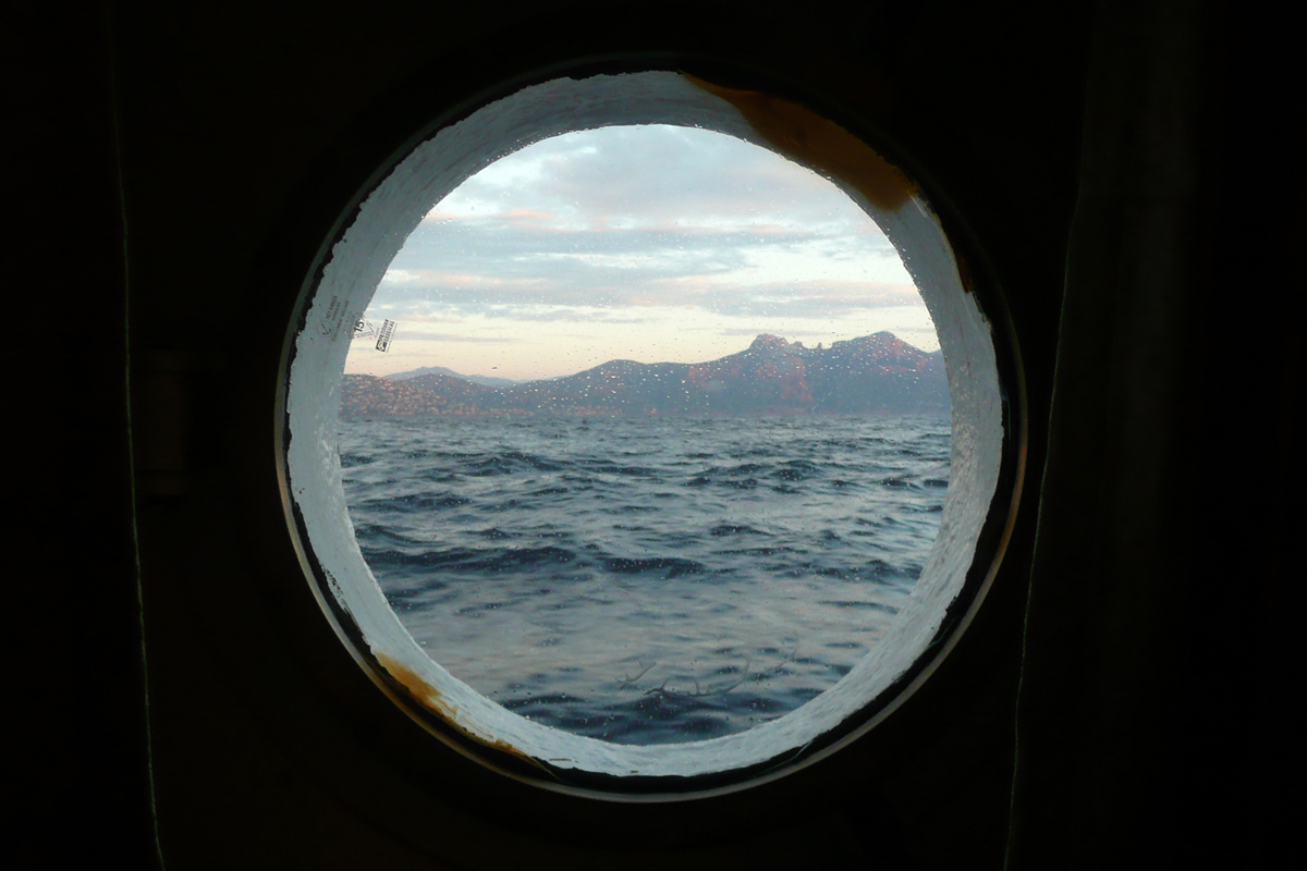 Blick aus dem Bullauge einer Kabine auf die südfranzösische Küste bei Marseille.